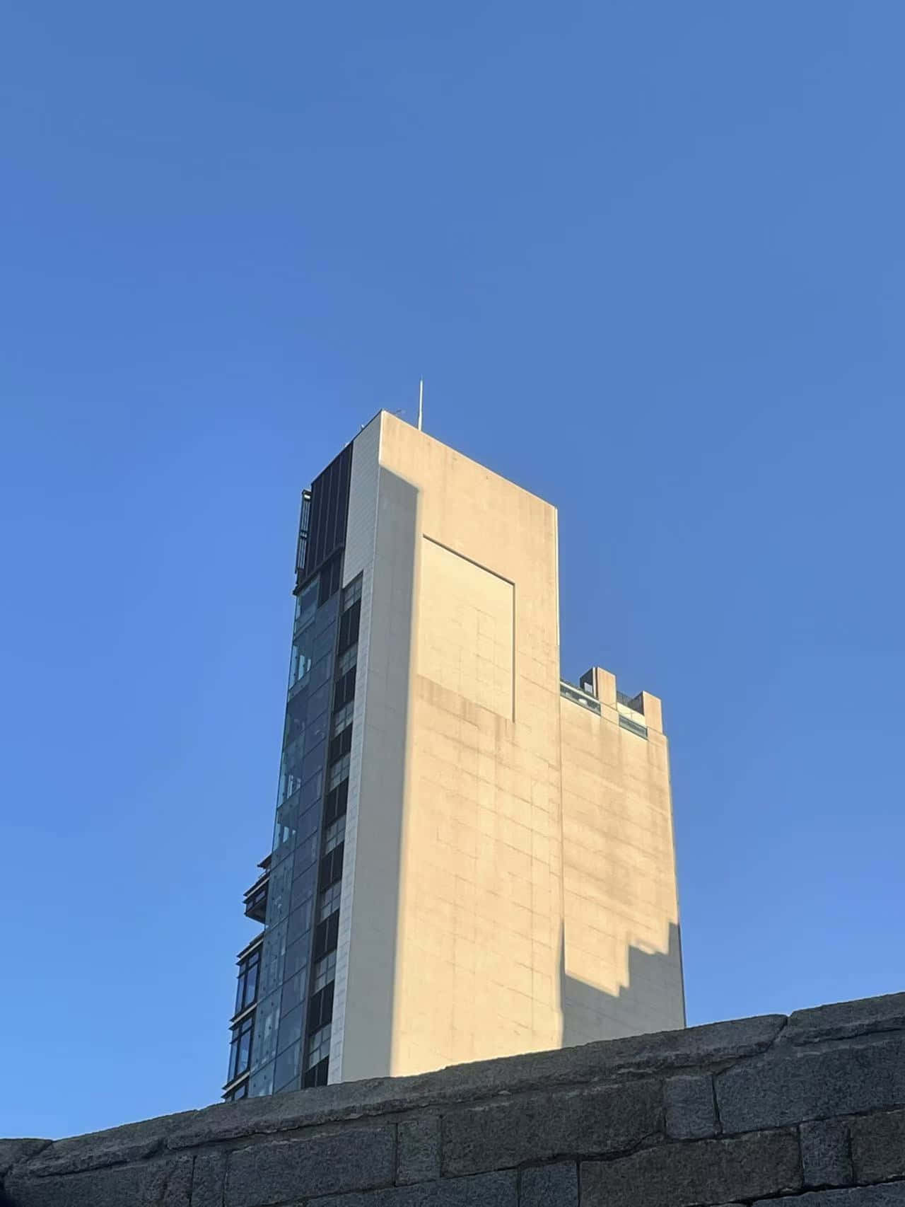 明亮的藍天下，擁有混凝土和玻璃外牆的高層現代建築