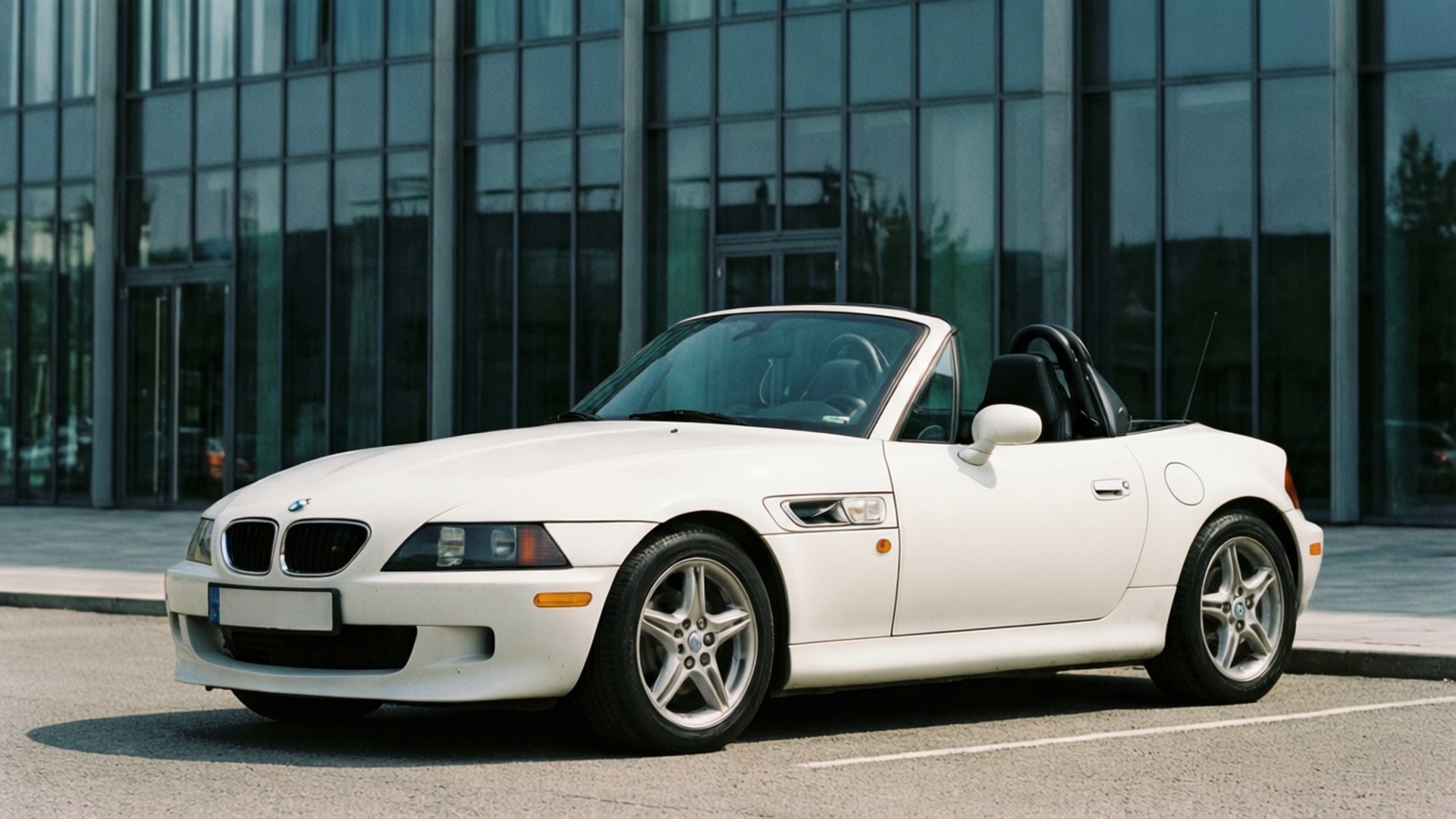 白色BMW Z3開篷車停泊在玻璃建築前