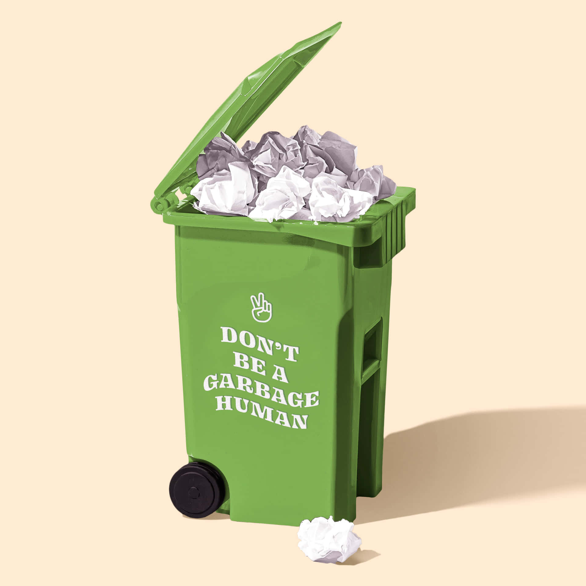 綠色垃圾桶，上面有「Don't be a garbage human」標語，裡面裝滿皺巴巴的紙張。