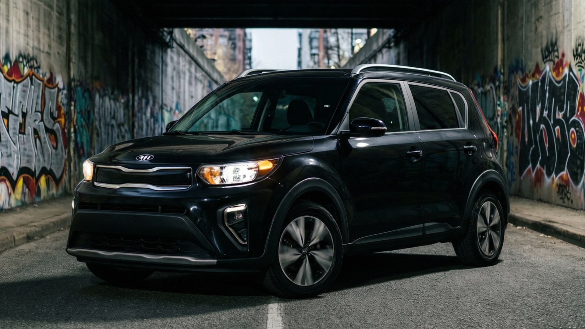 都市邊緣隧道 壁紙 — 一輛時尚的黑色Kia Soul SUV在佈滿塗鴉的城市隧道中行駛，車頭燈亮著。
