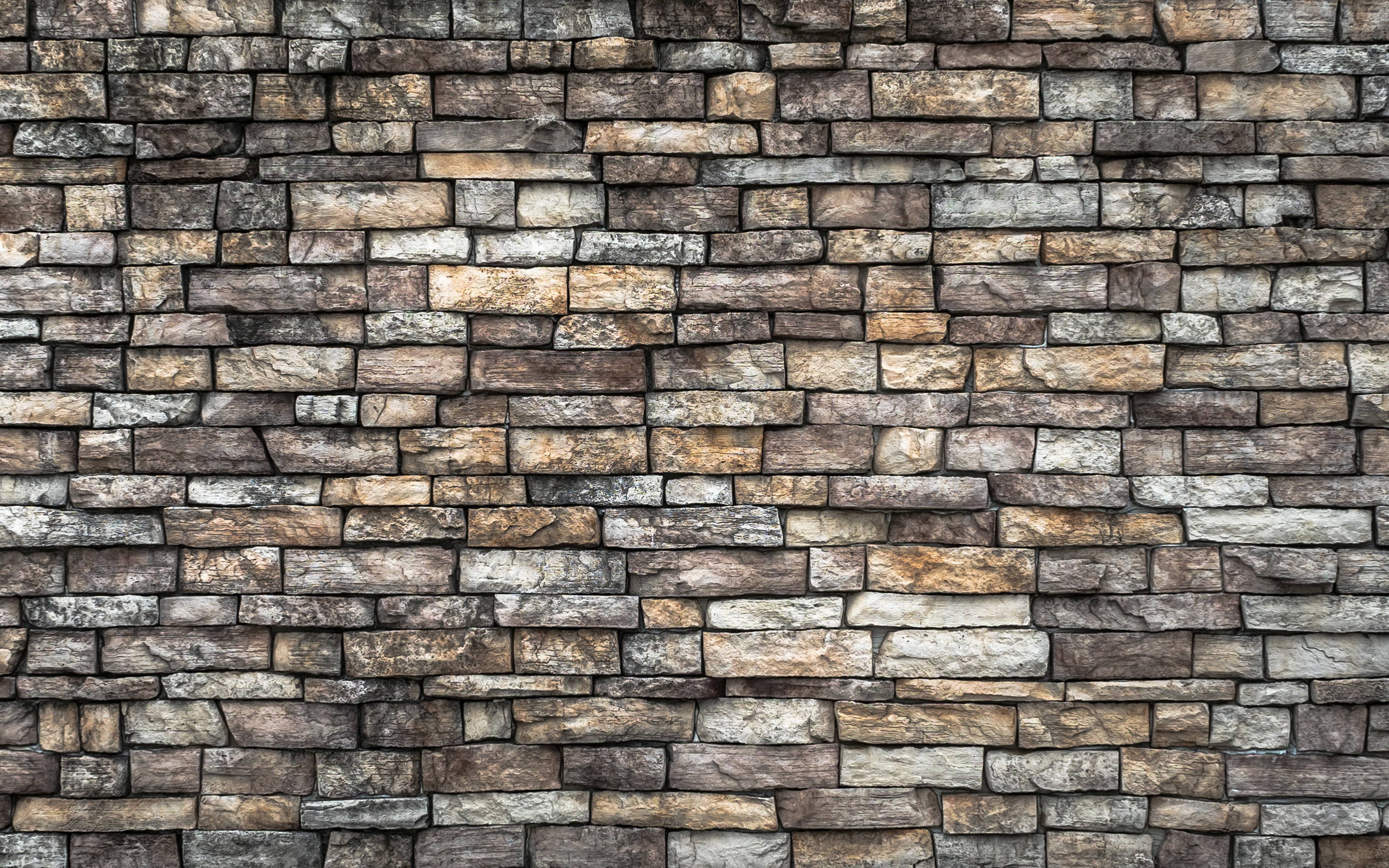 Stone Wall 桌布 壁紙 — 鄉村風格石牆的特寫，具有多種大地色調和粗糙質感。
