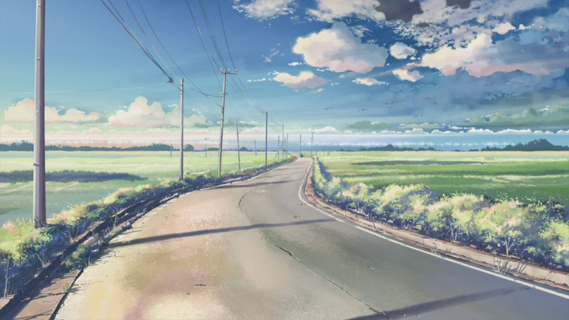 一條寧靜的鄉村道路，兩旁是綠色的田野，上方是明亮的藍天，點綴著幾朵白雲。