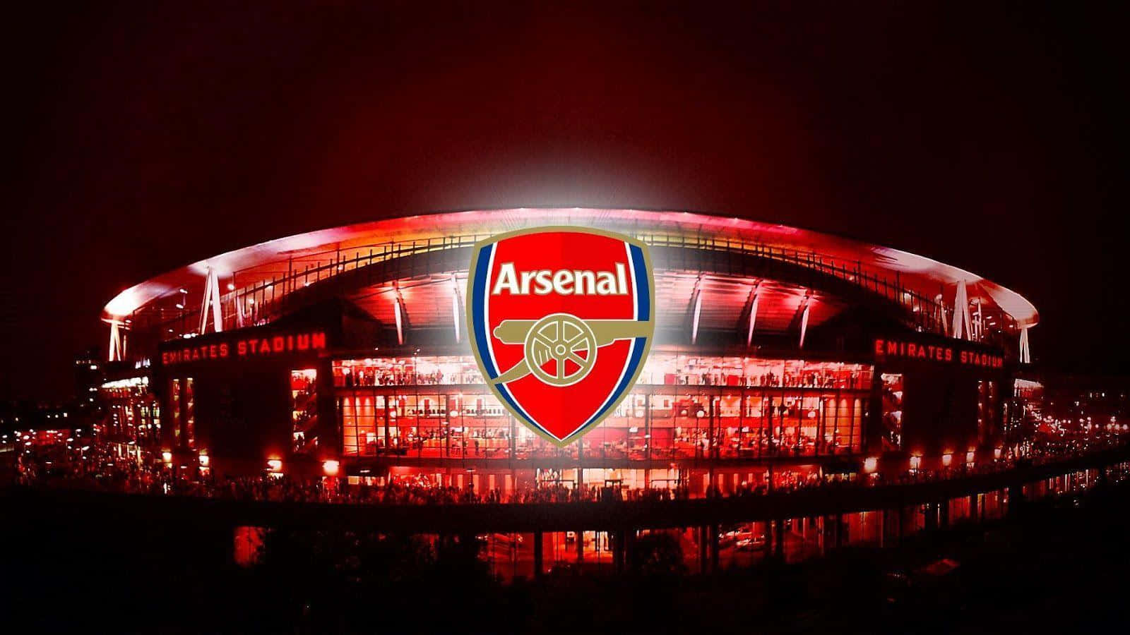 Arsenal 桌布 壁紙 — 酋長球場在夜晚閃耀紅光，阿仙奴標誌在座無虛席的看台上方亮起。