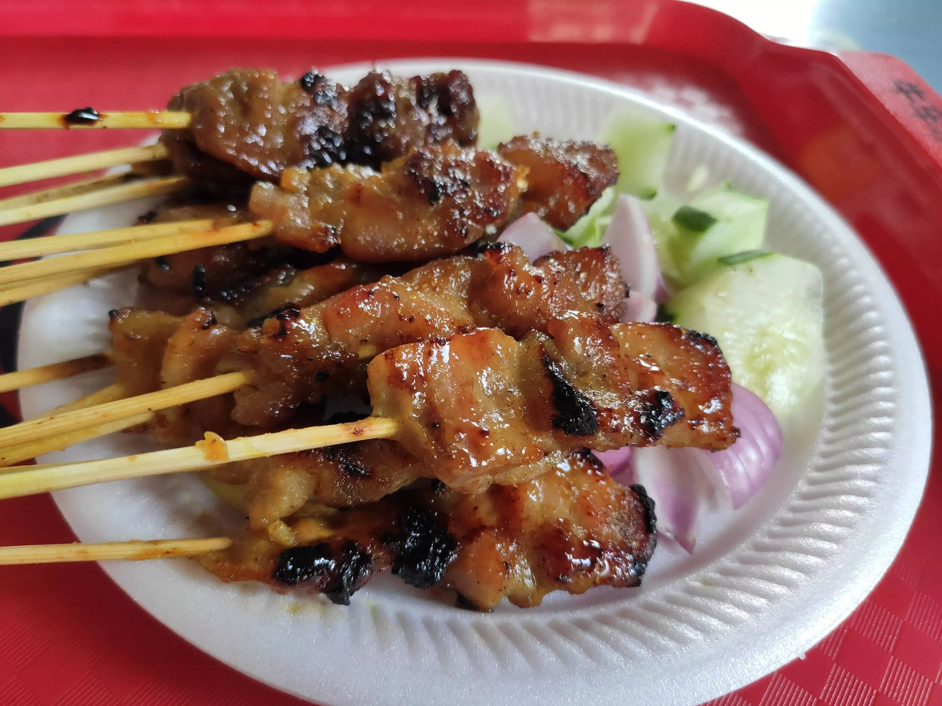 白色盤子上的烤肉串、青瓜和洋蔥。