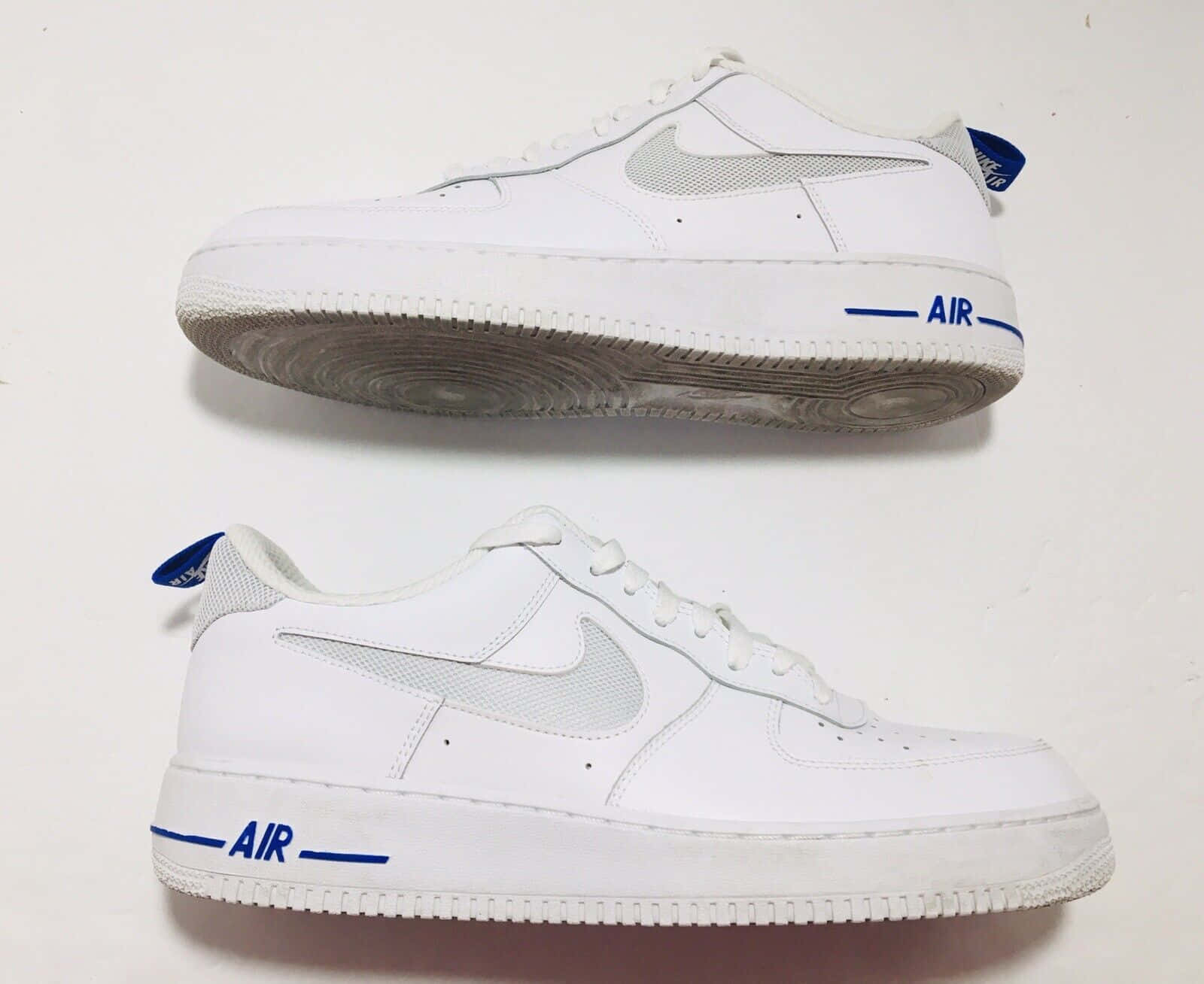 帶有藍色細節的白色Nike Air Force 1運動鞋，從頂部和側面展示。