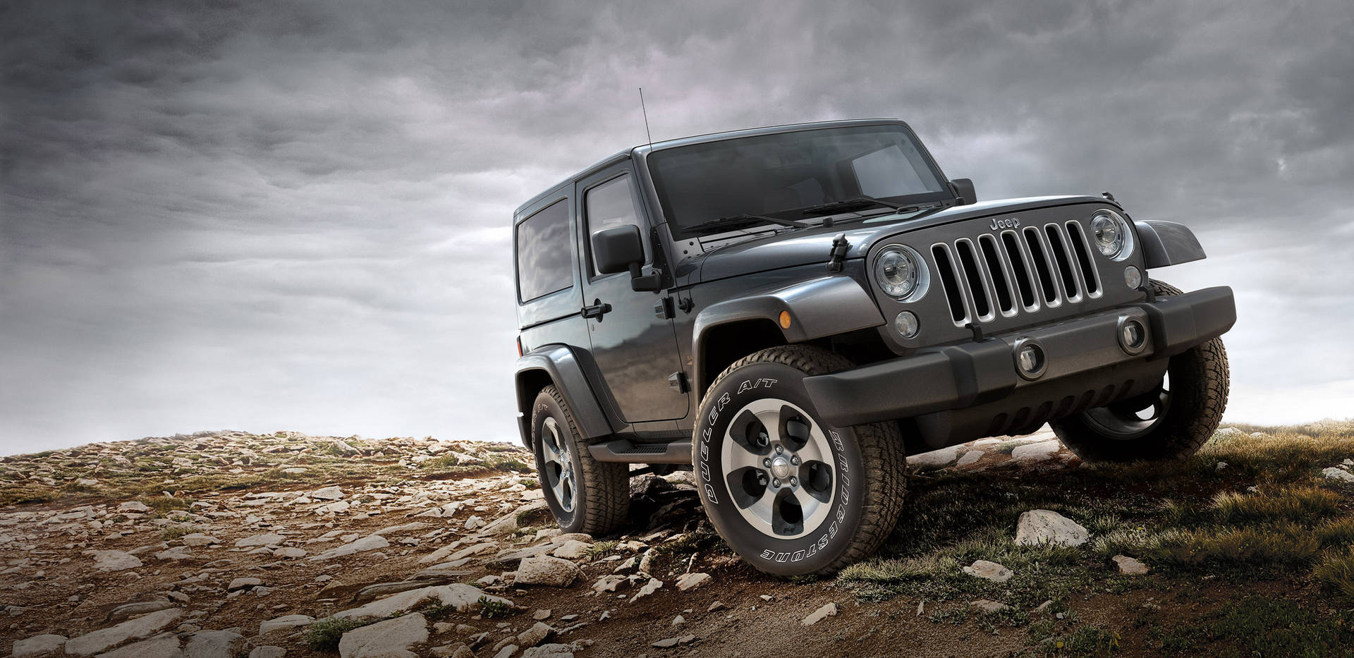黑色Jeep Wrangler在岩石地形上，戲劇性陰天