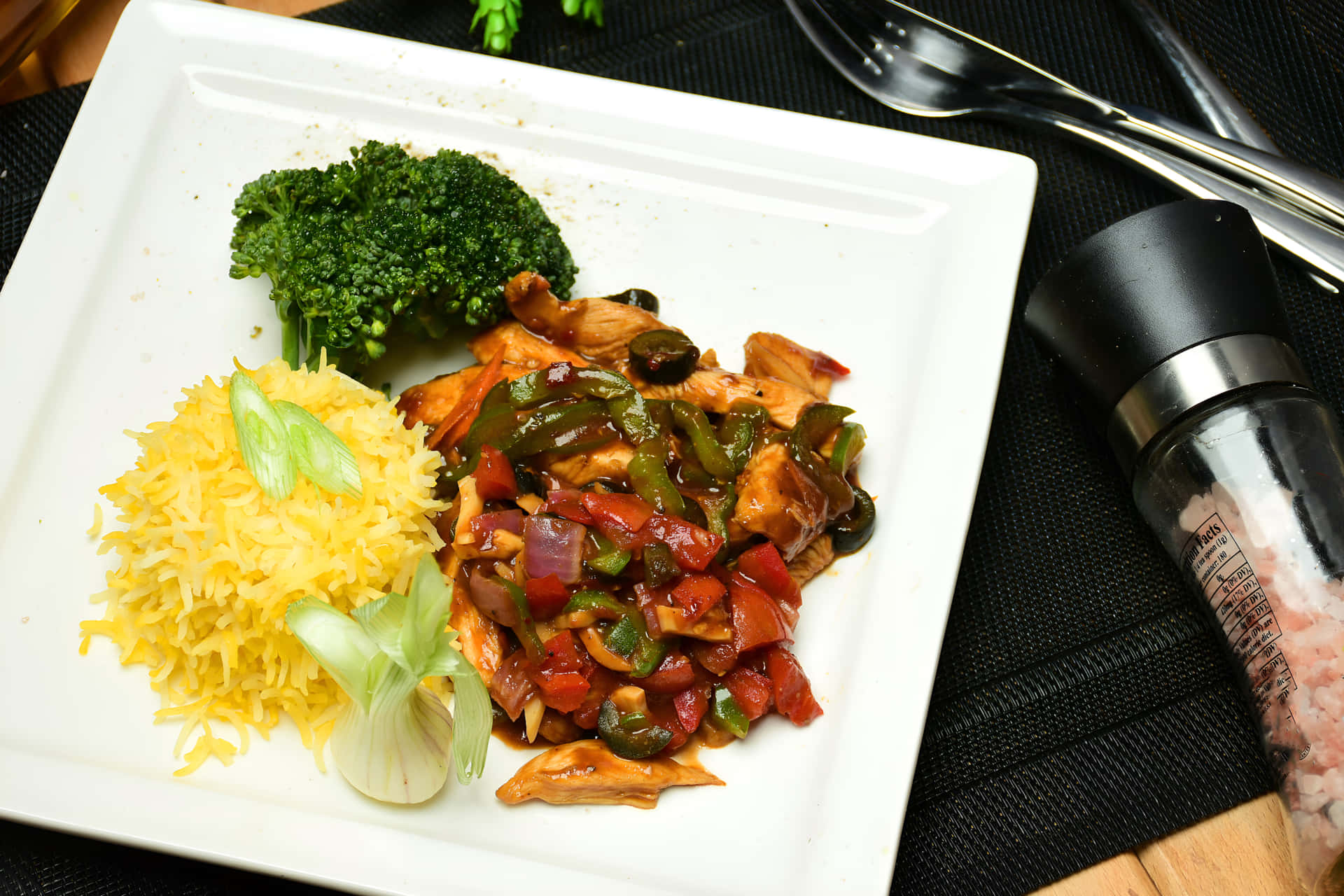 雞肉炒配燈籠椒洋蔥黃色飯和西蘭花的餐盤