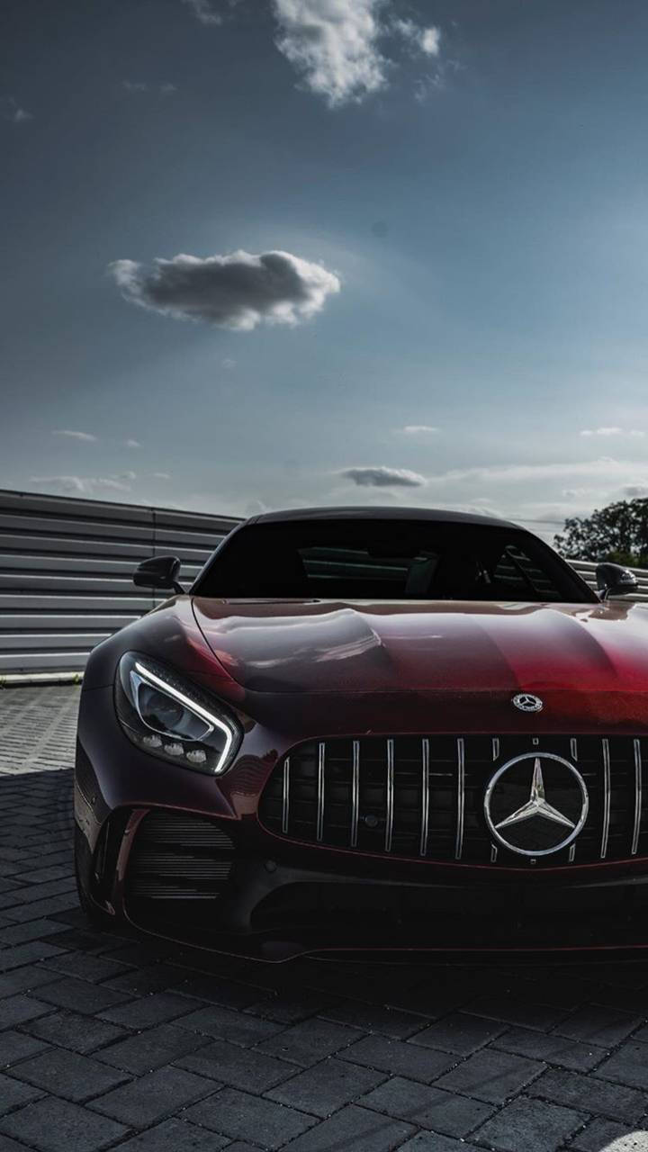 紅色Mercedes-AMG GT跑車停泊在賽道護欄附近的鵝卵石上。