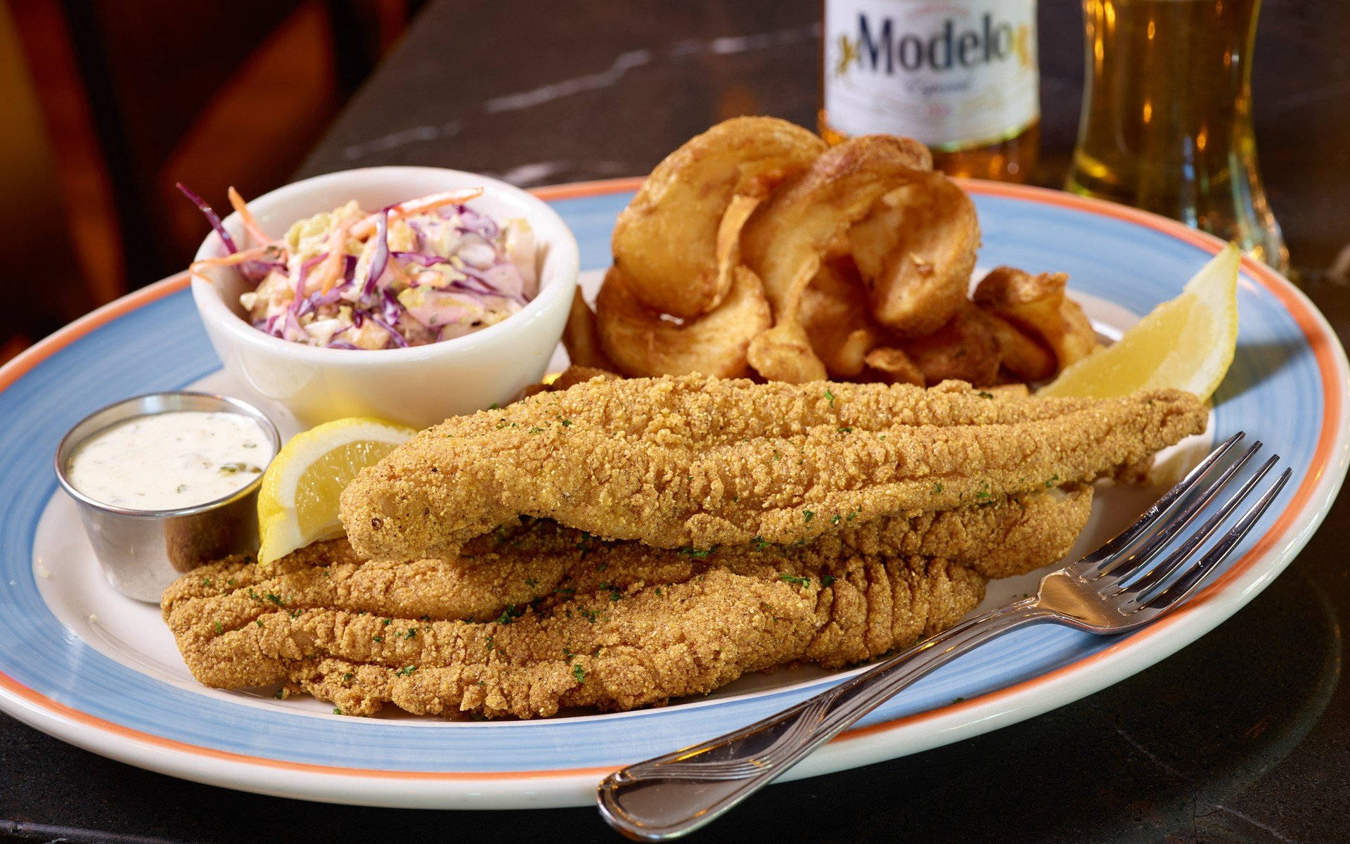 酥脆炸魚午餐 壁紙 — 香脆金黃魚柳和洋蔥圈，配上椰菜沙律和他他醬，放在色彩繽紛的碟上，伴以檸檬角。