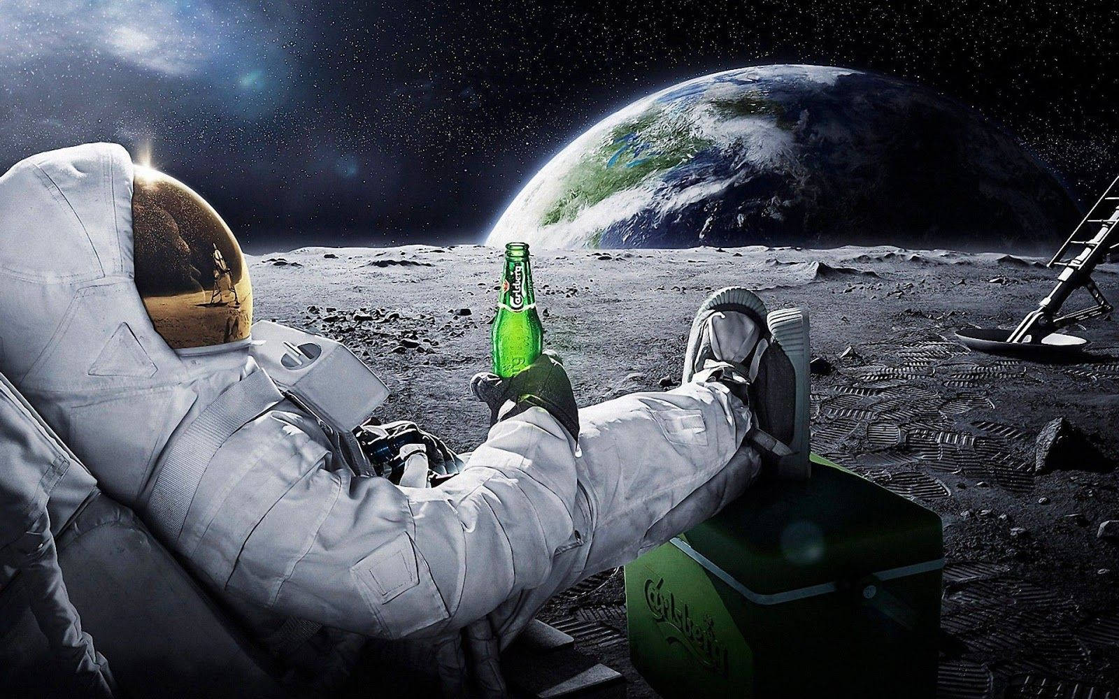 酷PC 月球上的男人 壁紙 — 一名太空人在月球上放鬆，手持綠色啤酒瓶，地球在他們身後繁星點點的天空中升起。