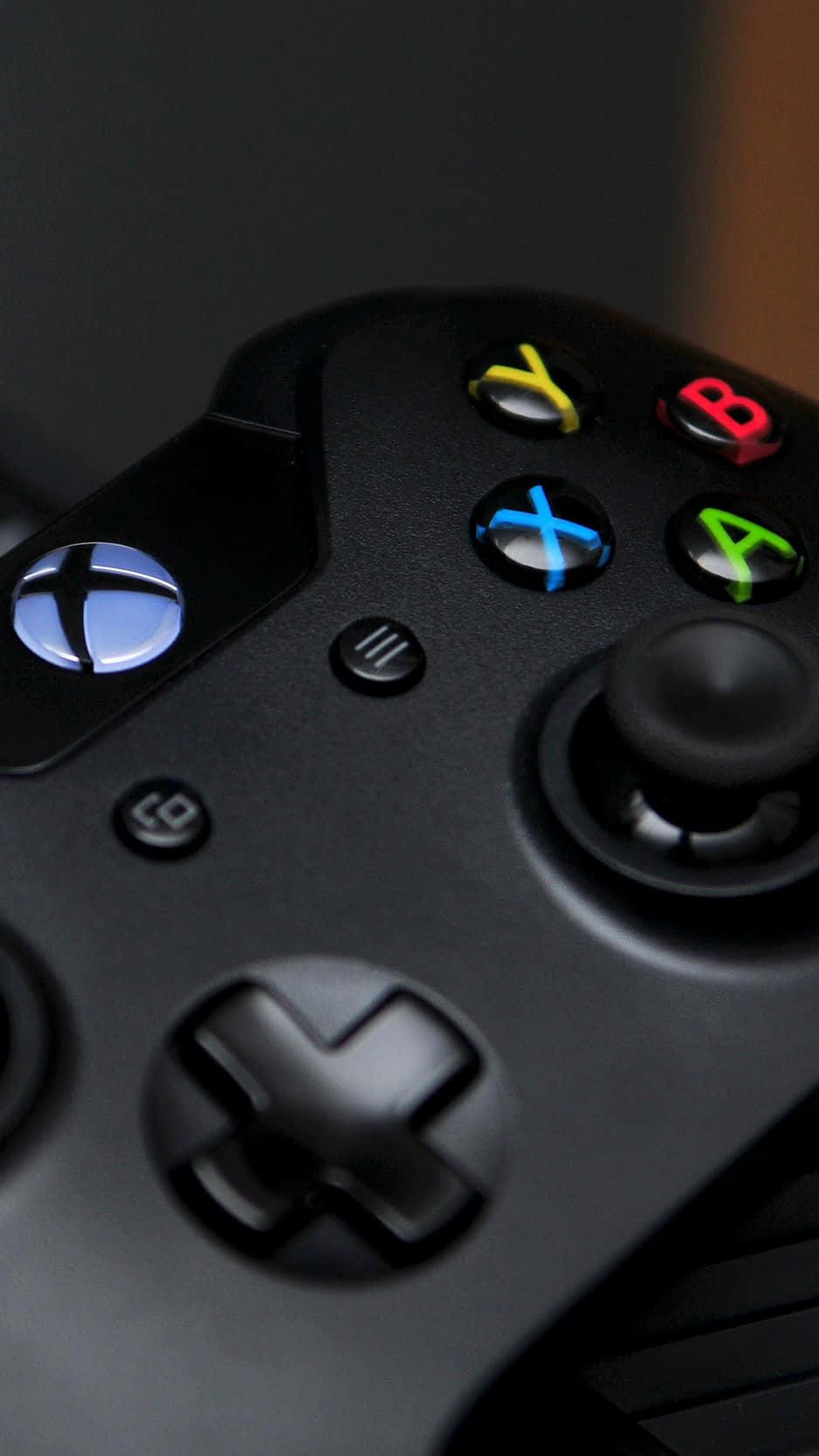 酷Xbox控制器 壁紙 — 黑色Xbox手掣特寫，帶有發光彩色按鈕和發光標誌，背景為深色。