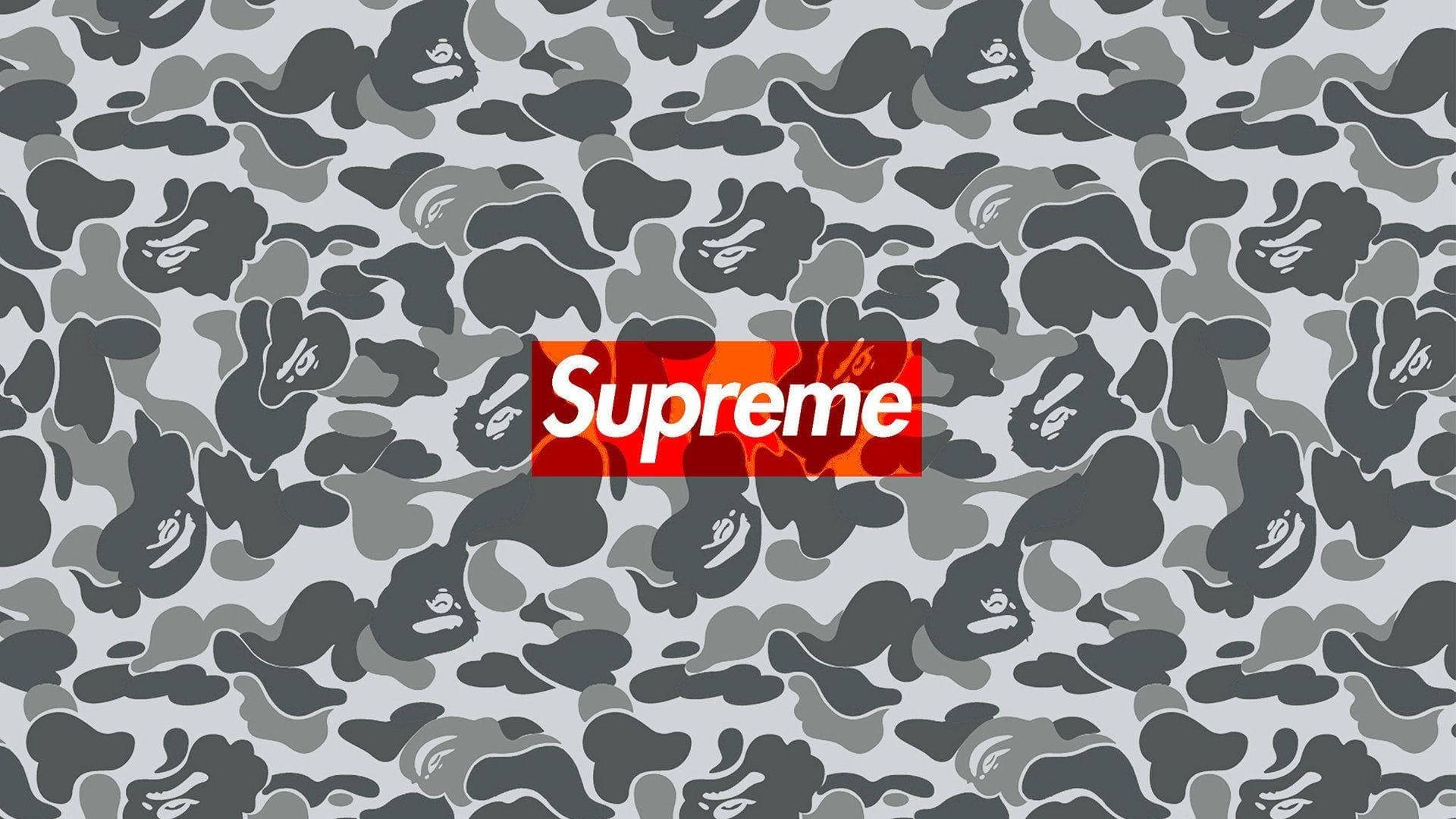 酷炫 Supreme 灰色迷彩 壁紙 — 一個大膽的紅色Supreme標誌居中在灰色迷彩圖案上，帶有重複的猿頭剪影。