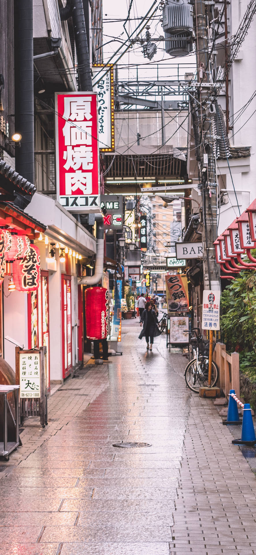 日本雨中小巷，發光霓虹燈招牌和濕漉漉的路面反射光線。