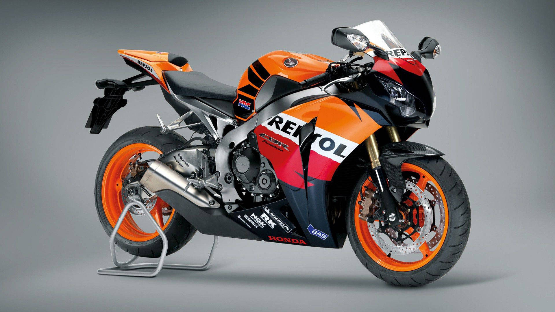橙色和黑色的Honda Repsol賽車摩托車在工作室中展示。