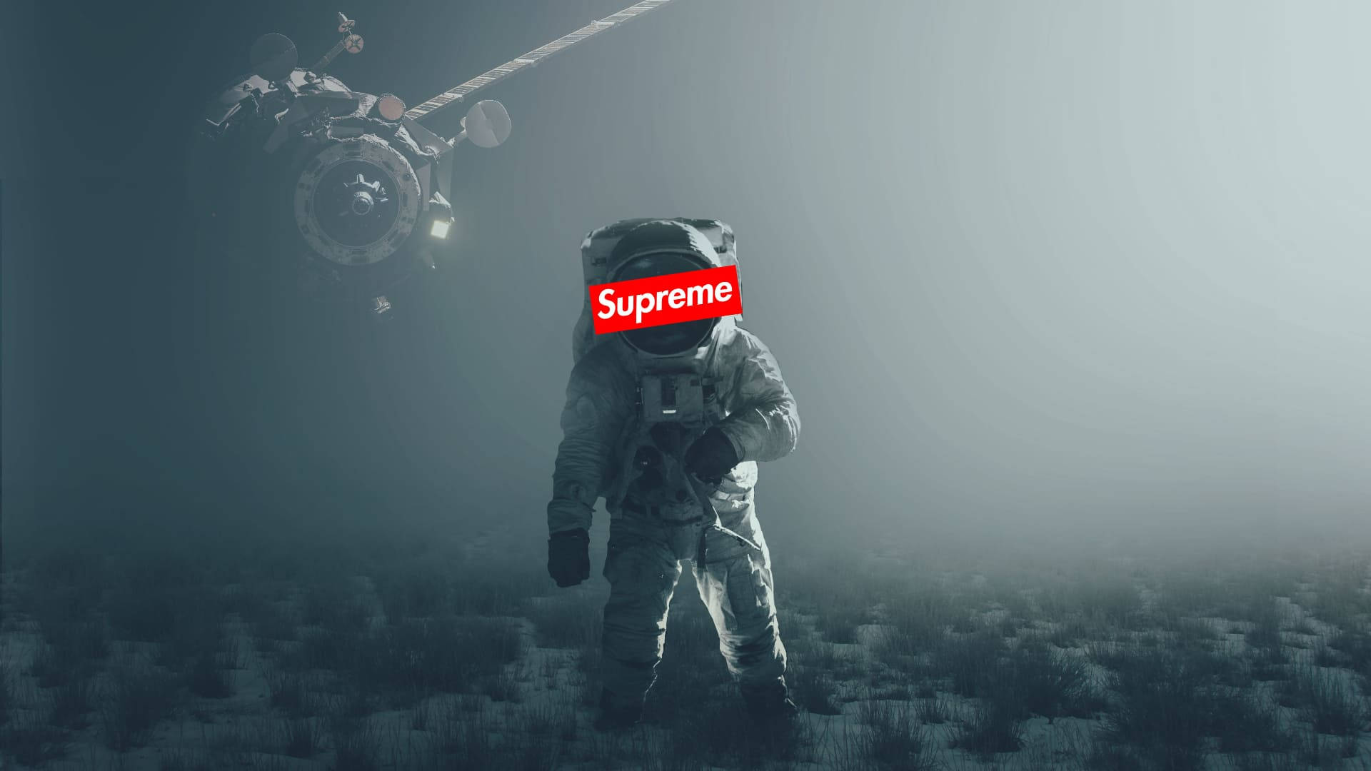 酷炫Supreme深空氛圍 壁紙 — 一名穿著灰色太空衣的太空人站在霧氣瀰漫的外星景觀上，頭頂有衛星盤旋，頭盔上帶有紅色Supreme標誌。