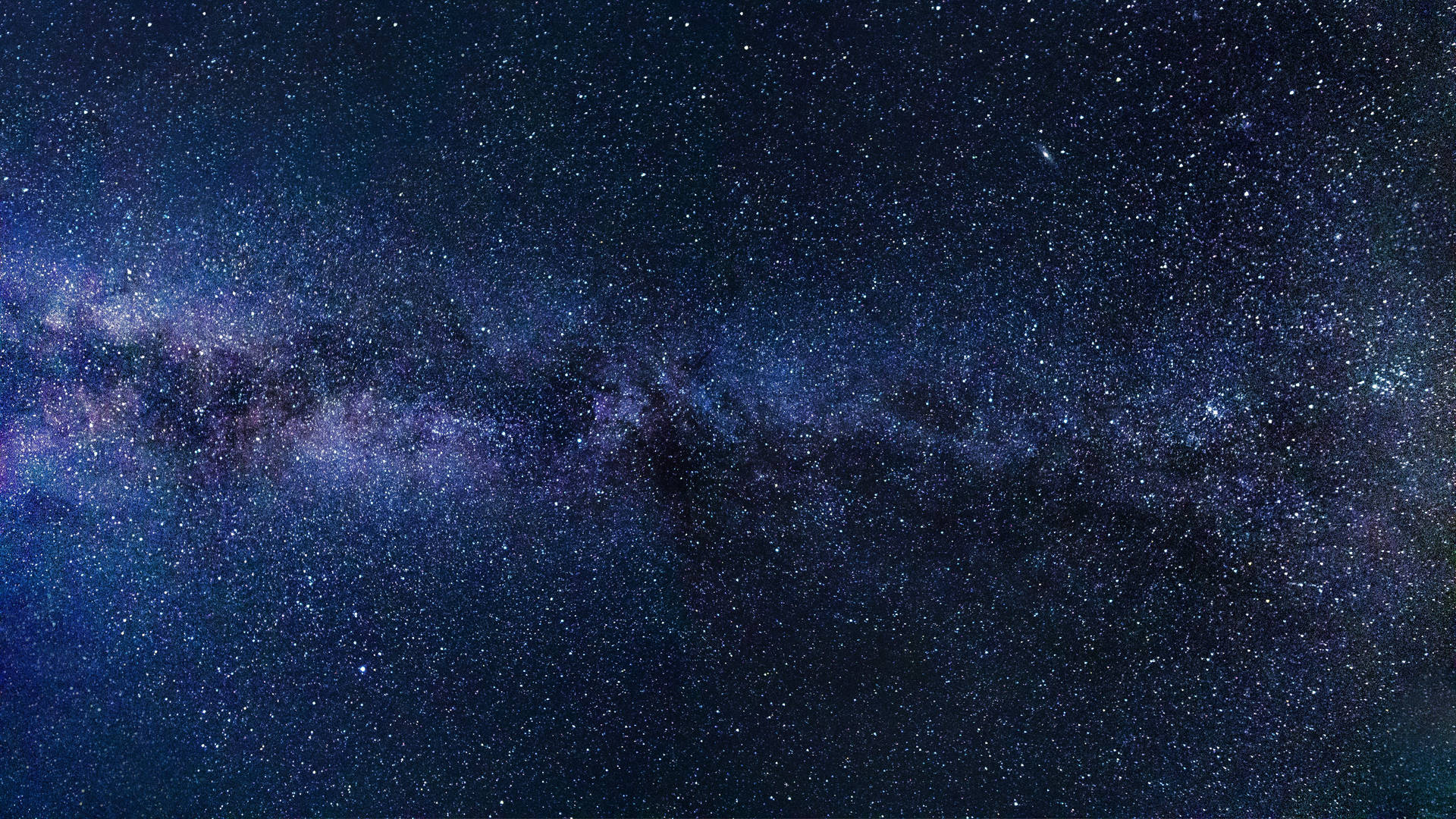 銀河系在黑暗的夜空中散發著紫色和藍色的星光。
