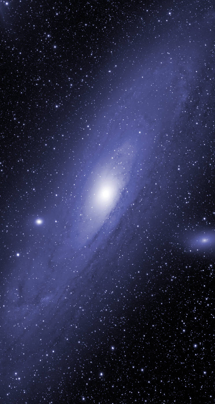 一個螺旋星系，核心明亮，藍紫色旋臂被星星環繞。