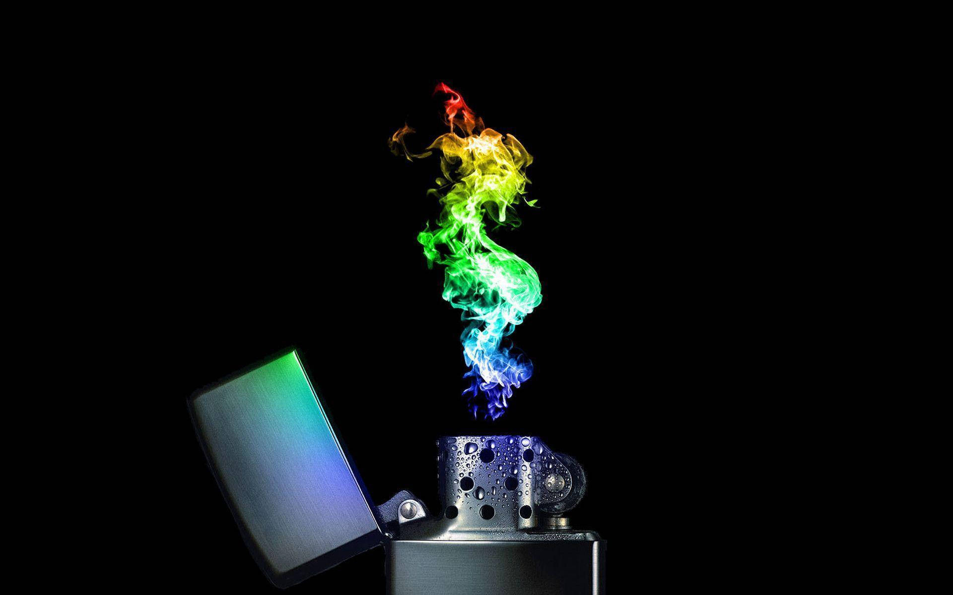 酷炫打火機火焰 壁紙 — 一個金屬打火機在純黑色背景下噴出充滿活力的彩虹煙霧螺旋。