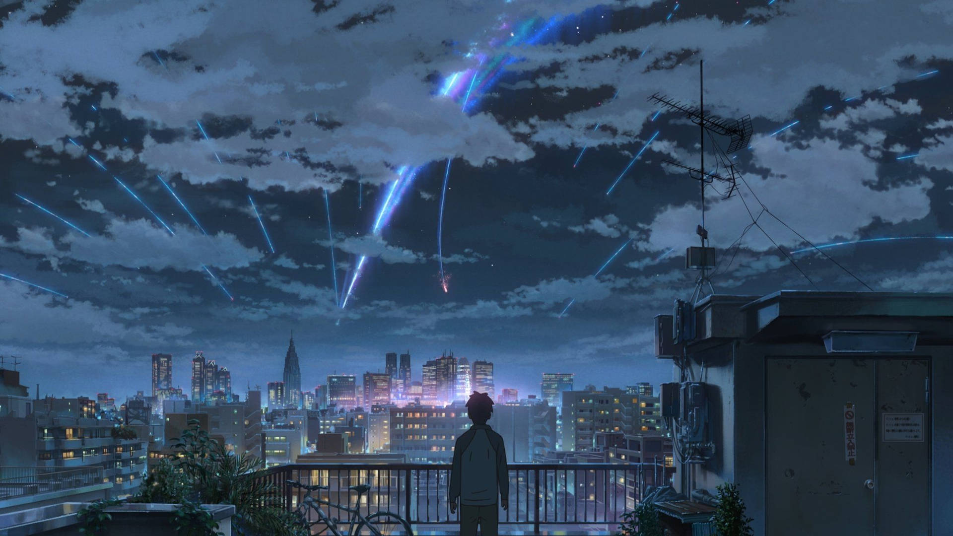 屋頂上的人在夜晚觀看城市上空發光的流星