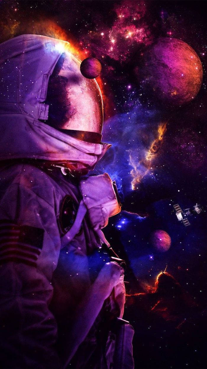 酷炫星系藝術 壁紙 — 一名太空人在色彩繽紛的星雲和行星之間漂浮，頭盔反射著宇宙的光芒。