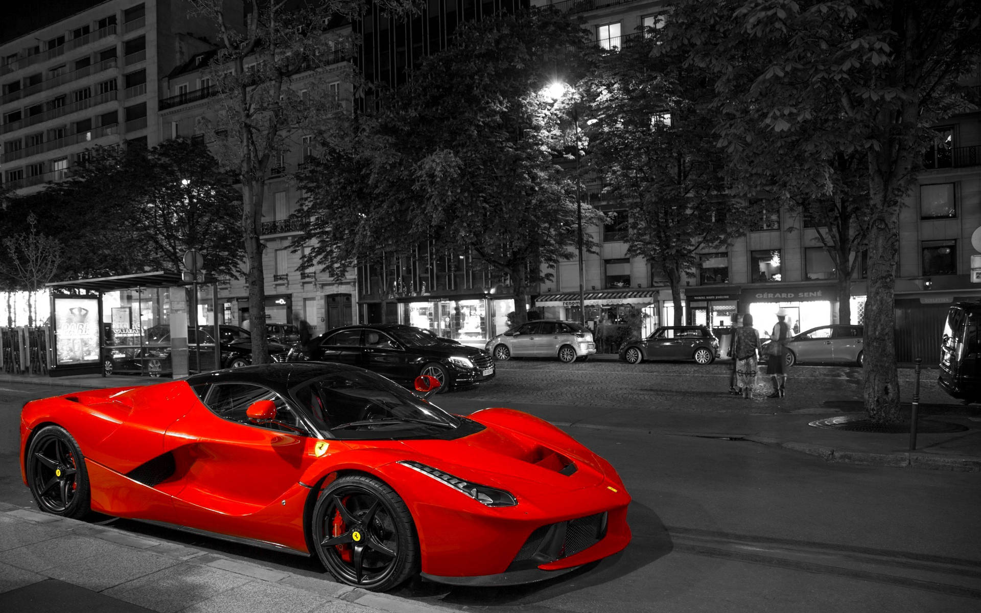 一輛紅色法拉利LaFerrari在夜間停泊在城市街道上。