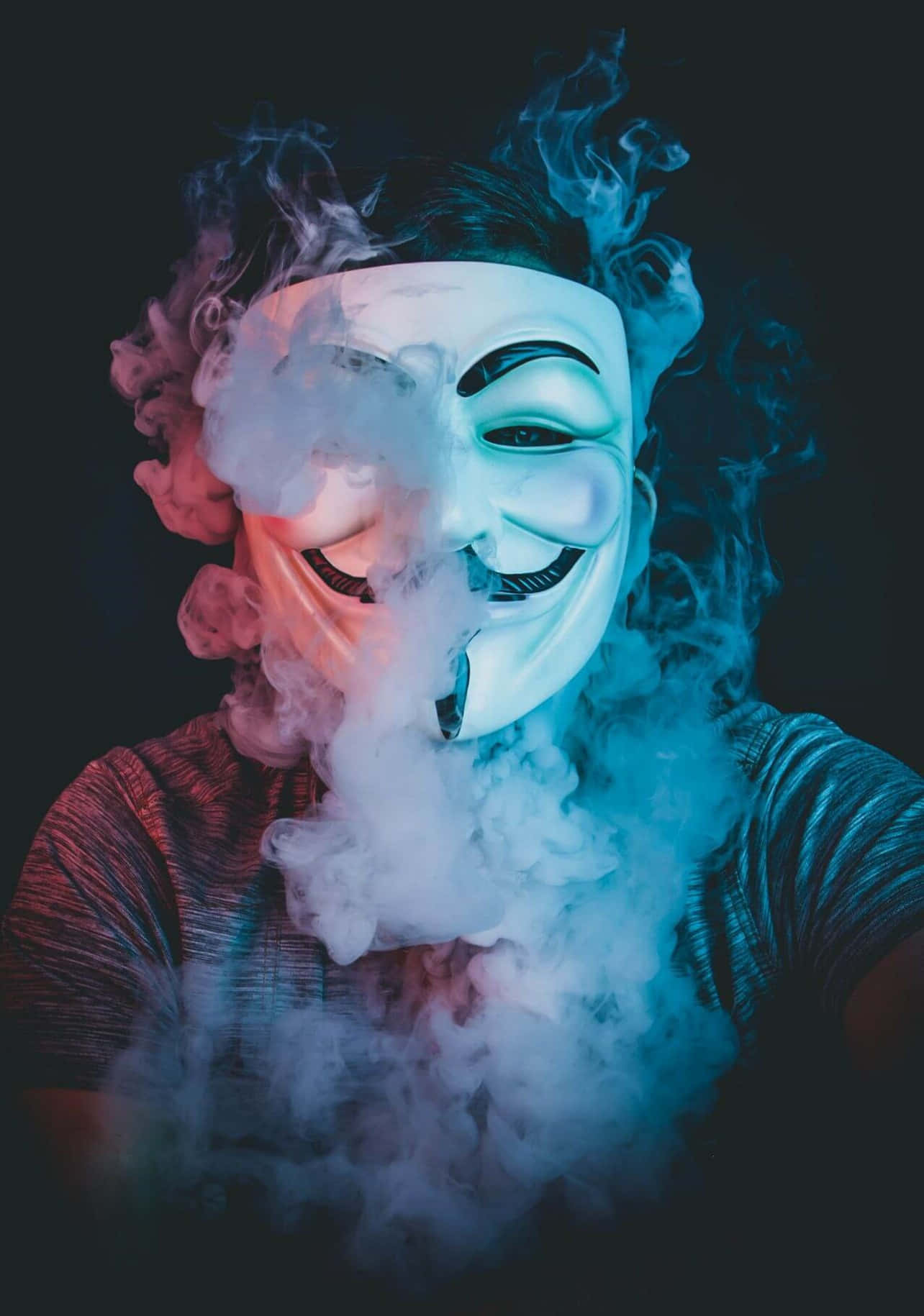 戴白色面具的人在黑暗環境中呼出彩色煙霧