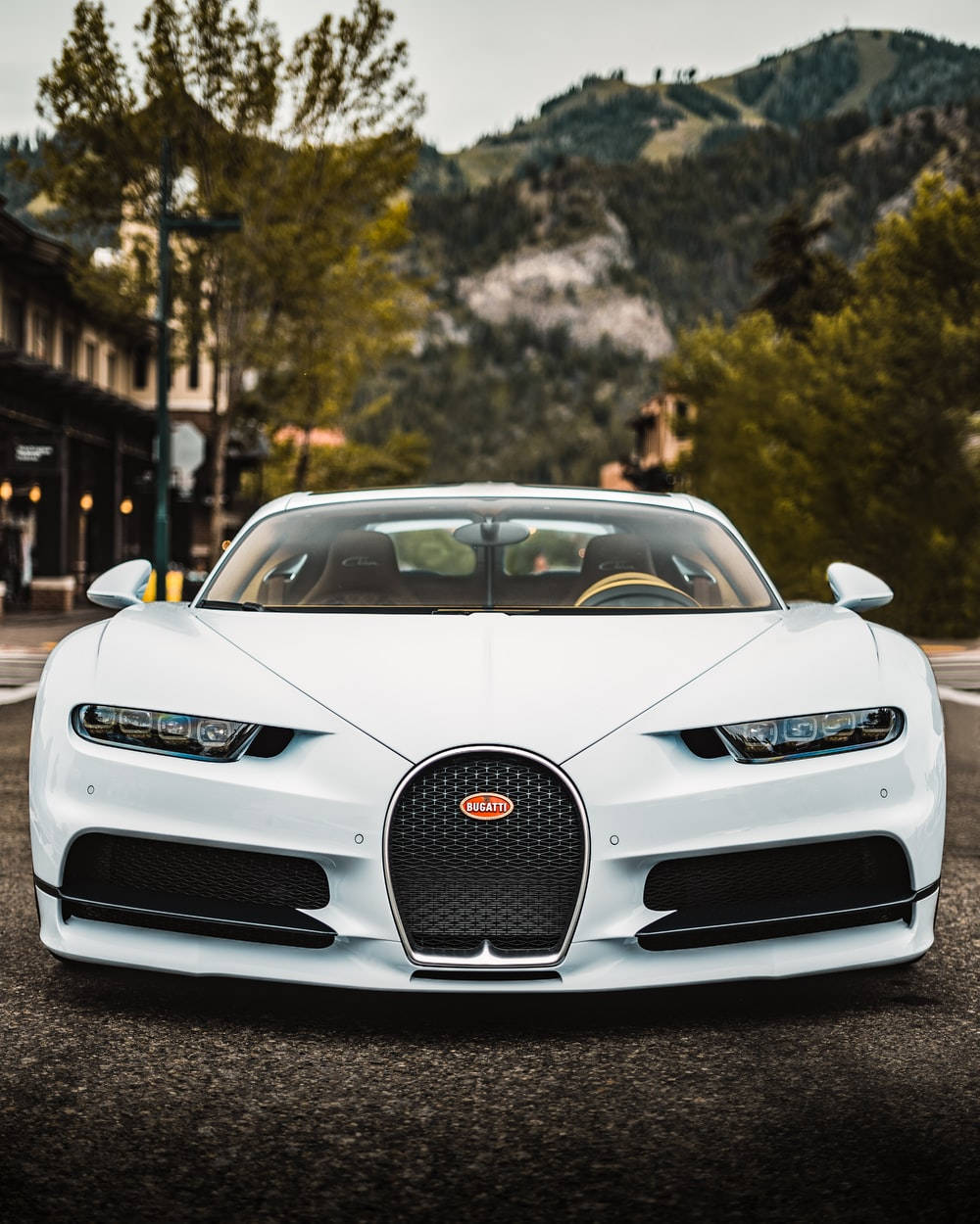 白色Bugatti跑車停泊在山城街道上。