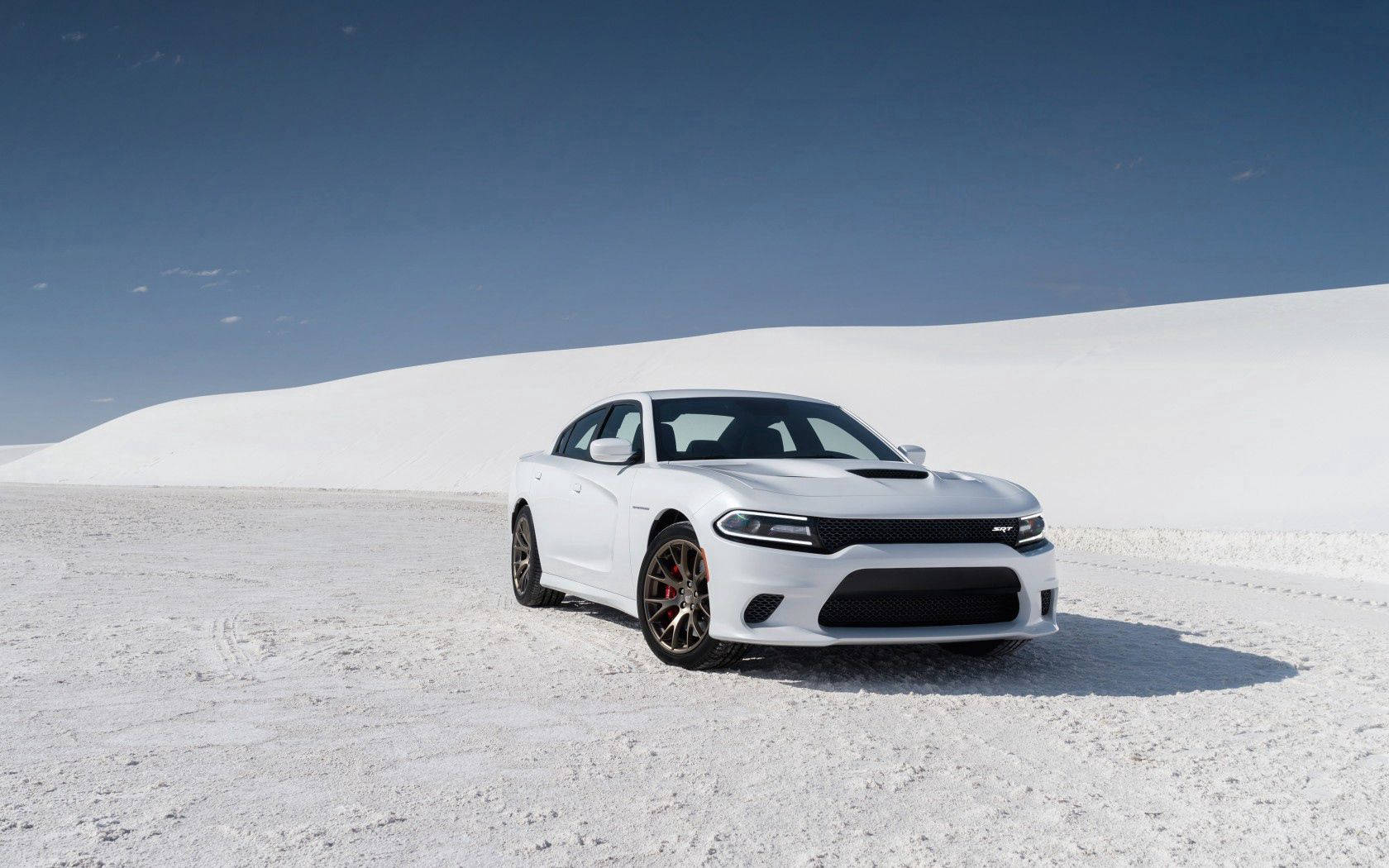 白色 Dodge Charger RT 在白色沙丘上，天空湛藍