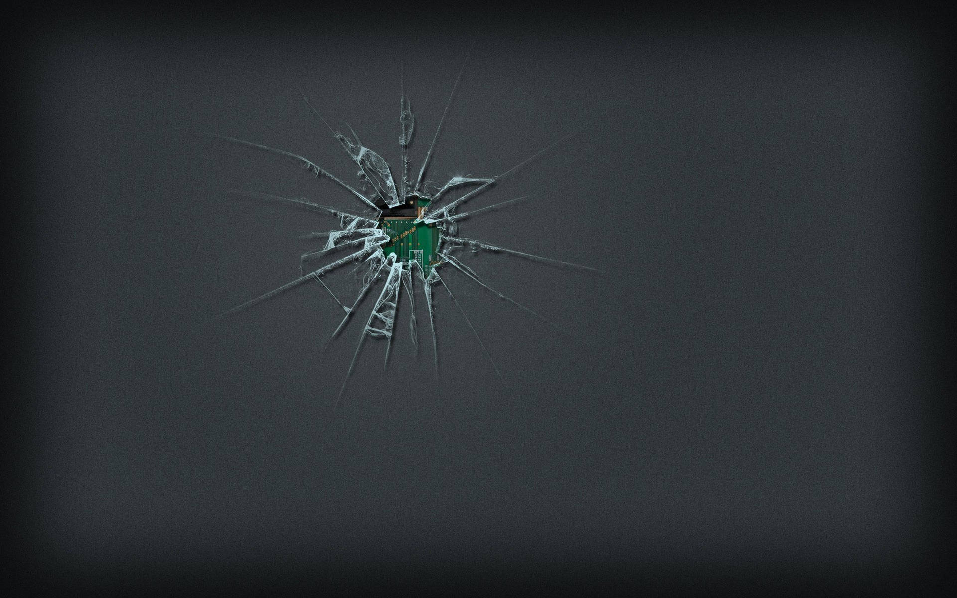 破碎的玻璃在深灰色背景上露出一個綠色物體。