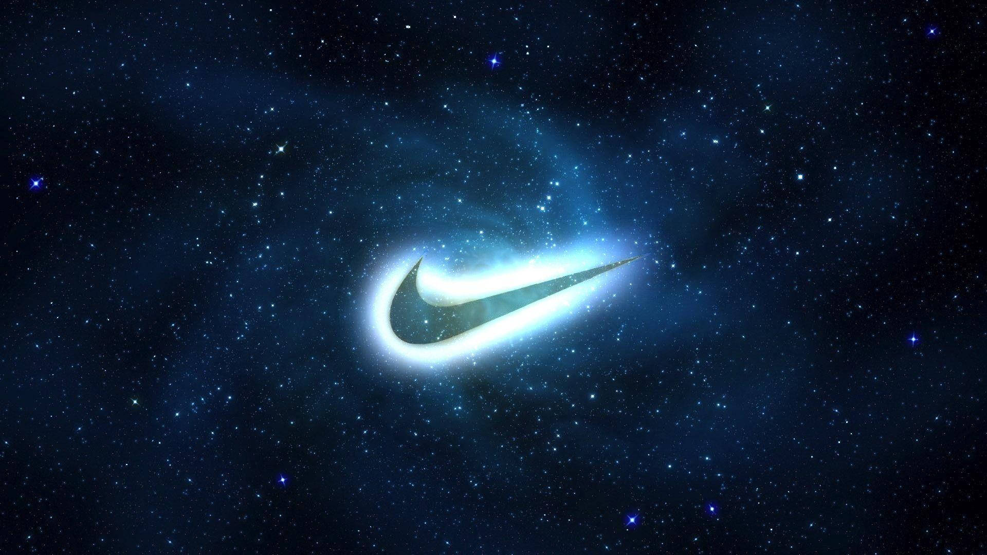 酷炫耐克星際背景 壁紙 — 發光的Nike勾號劃過佈滿星斗的宇宙星雲，散發出耀眼的藍白光芒。