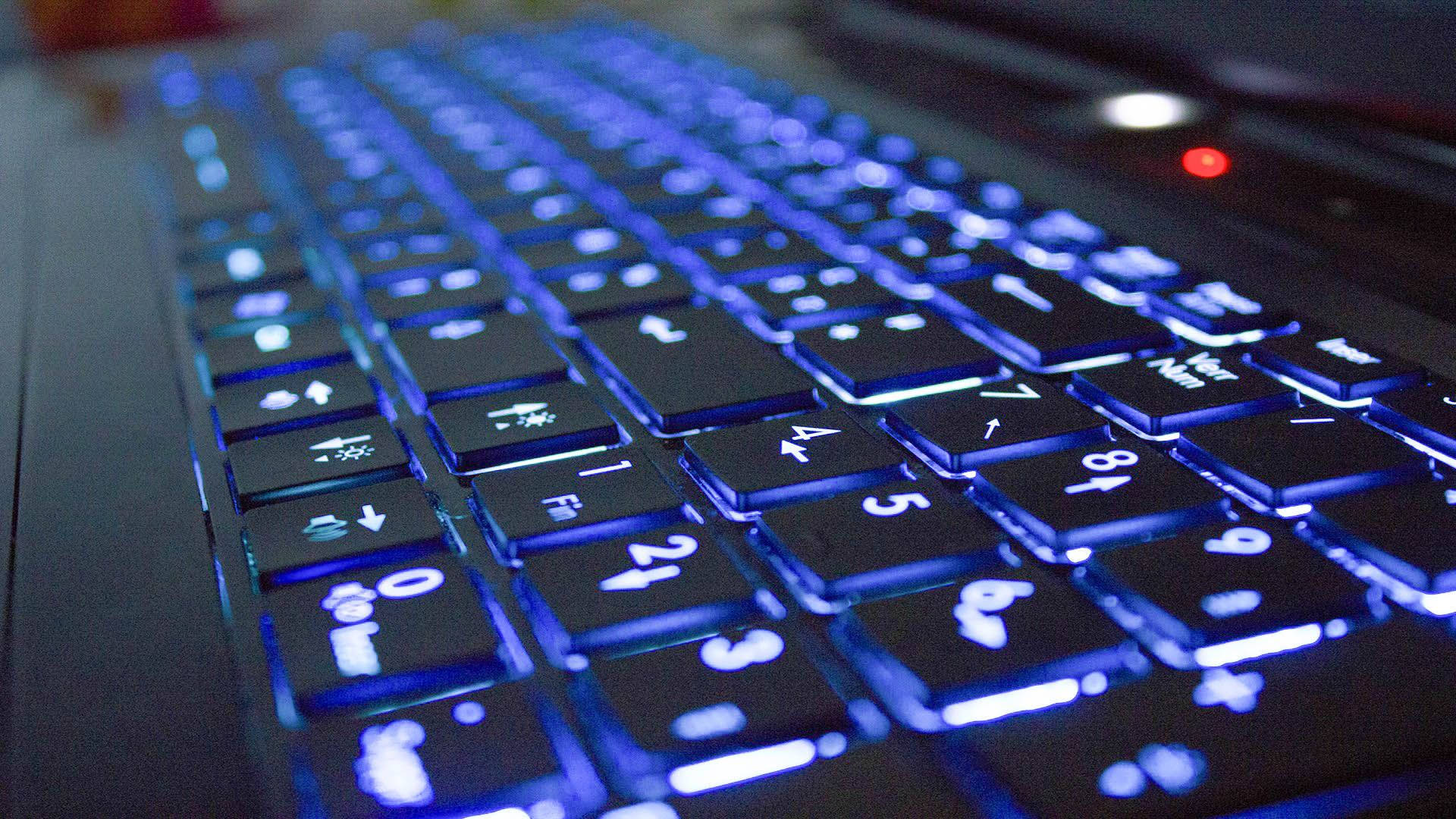 昏暗燈光下的藍色背光筆記型電腦鍵盤