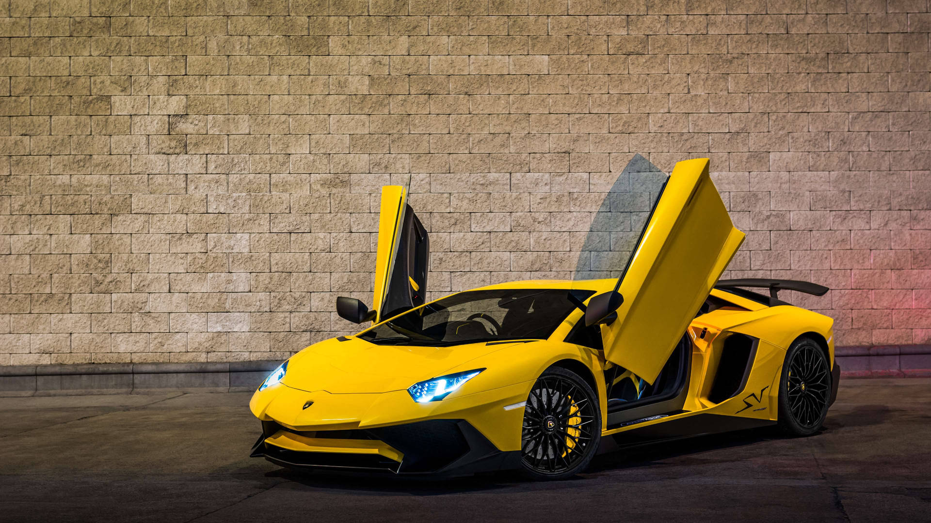 夜間，黃色林寶堅尼 Aventador 打開車門停在石牆旁。