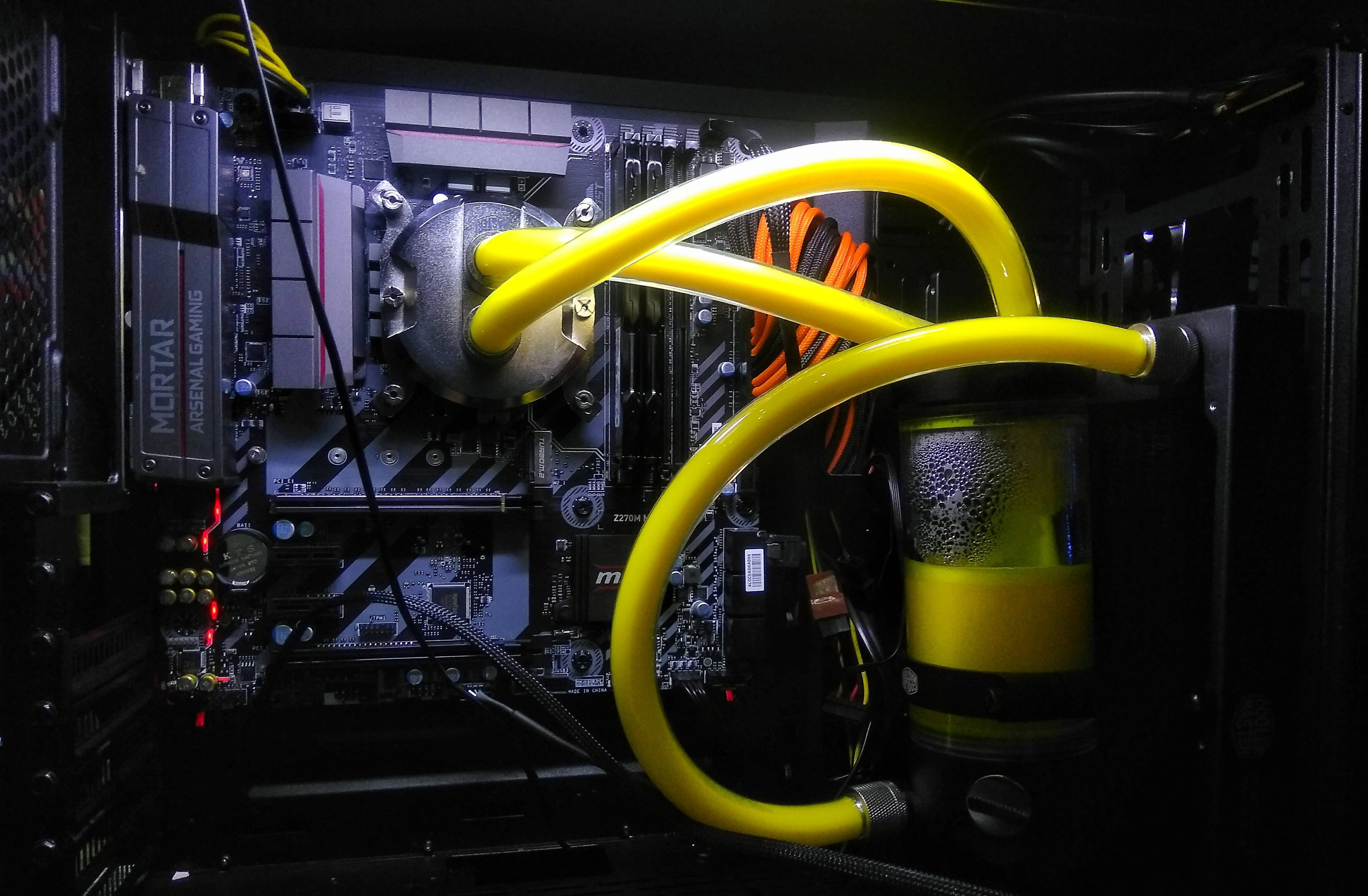 酷炫遊戲液冷GPU 壁紙 — 鮮黃色的液體冷卻管蜿蜒穿過深色電腦機箱，突顯複雜的主機板組件。