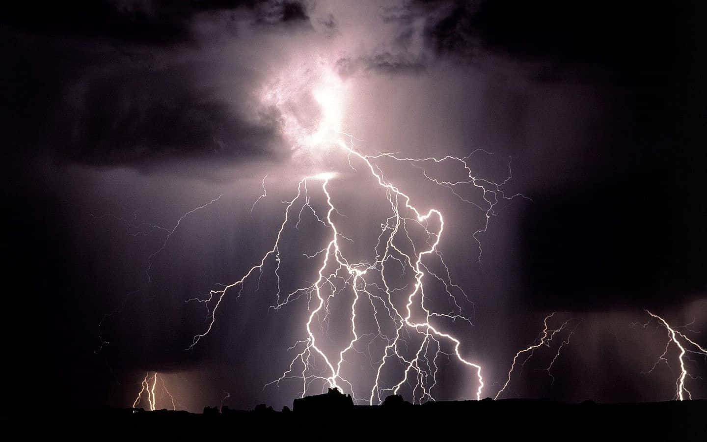 強烈的閃電在暴風雨的夜空中閃爍，劃過黑暗的景觀。