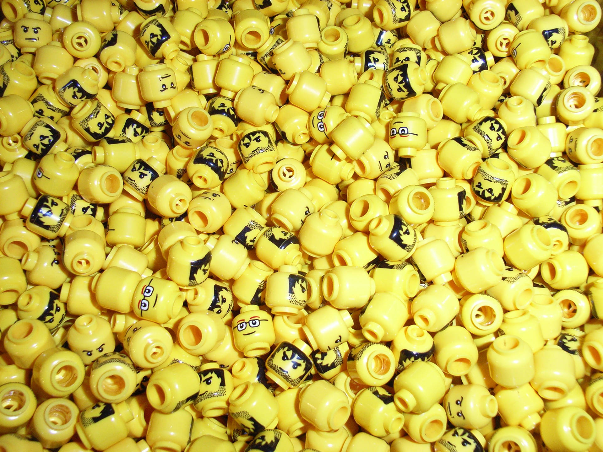 許多帶有不同表情的黃色LEGO迷你人偶頭部的特寫。