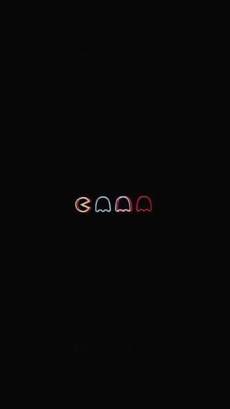 四個發光的 Pac-Man 鬼魂，以霓虹顏色在黑色背景上。