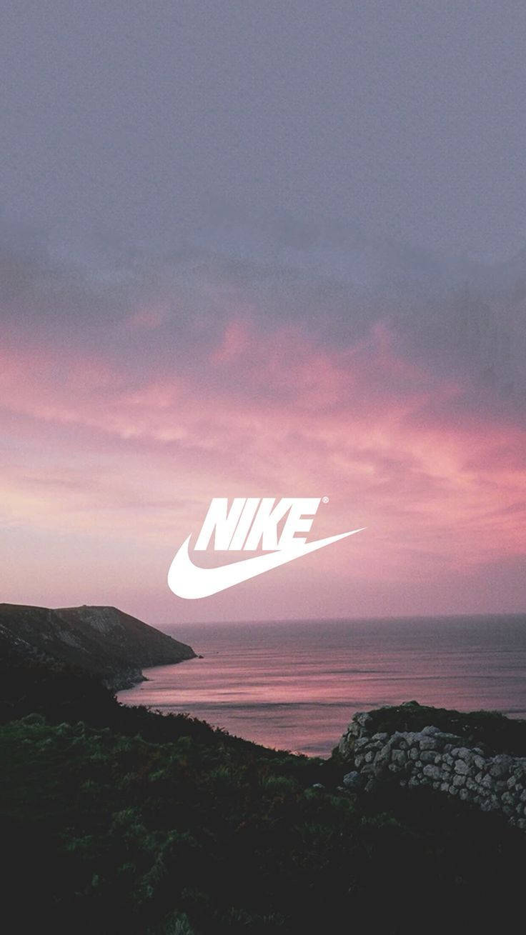 海邊粉紅色和紫色日落上的Nike標誌。