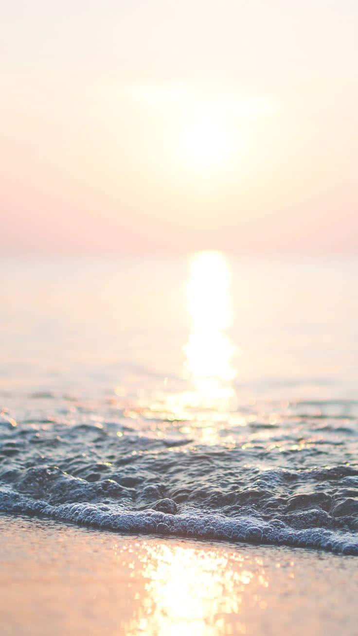 海洋上的夕陽，沙灘上有輕柔的波浪