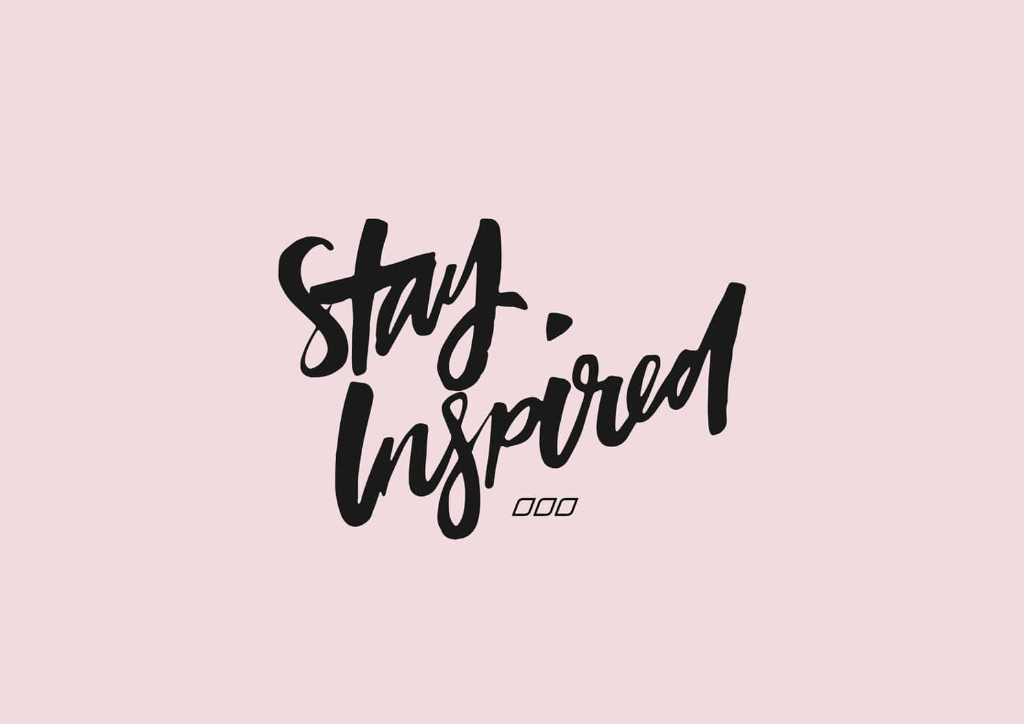 粉紅色背景上以黑色筆刷字體寫成嘅Stay Inspired勵志文字