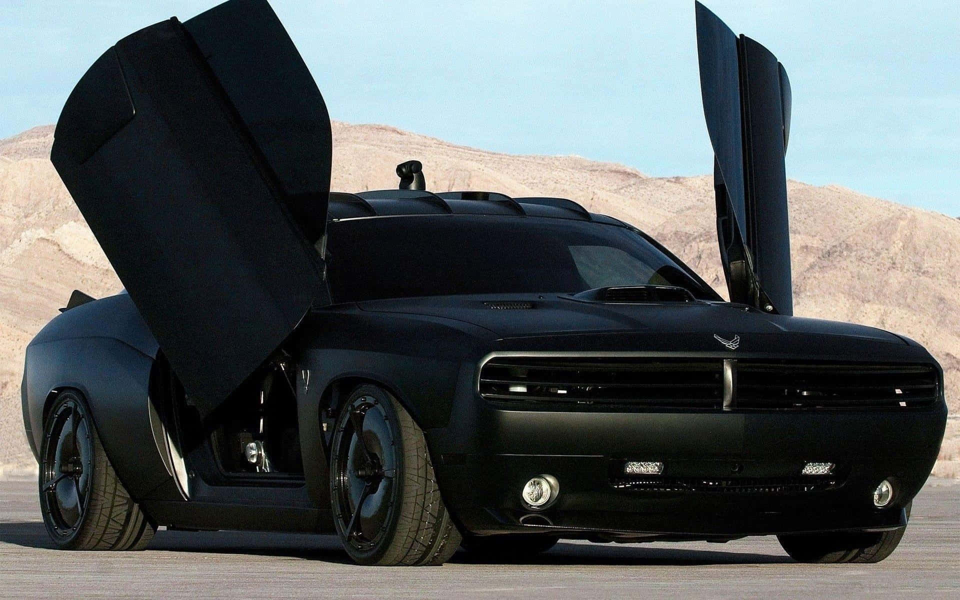 沙漠黃昏時打開鷗翼門嘅黑色Dodge Challenger。