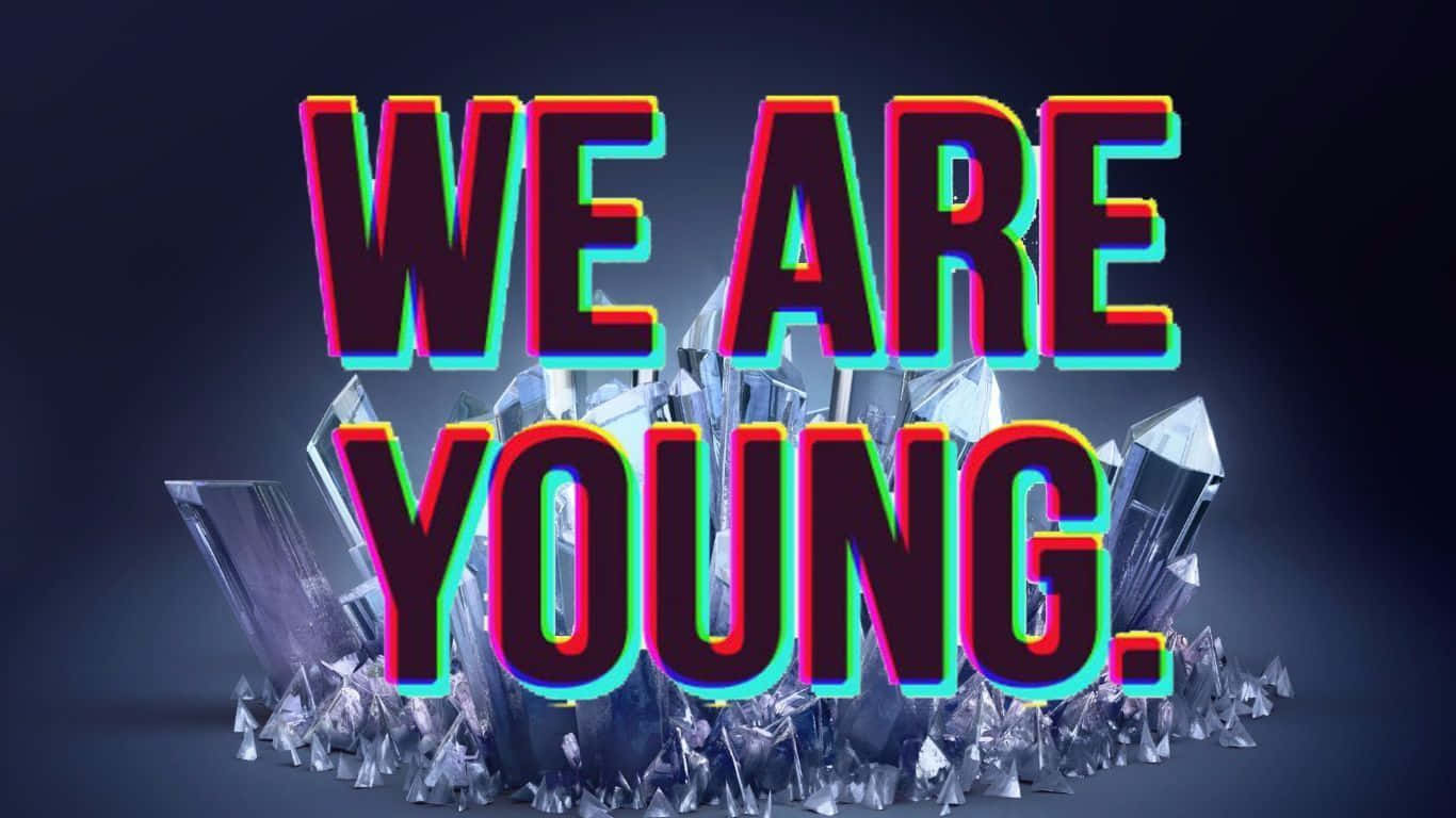 霓虹文字 WE ARE YOUNG 從玻璃晶體中升起，背景深色