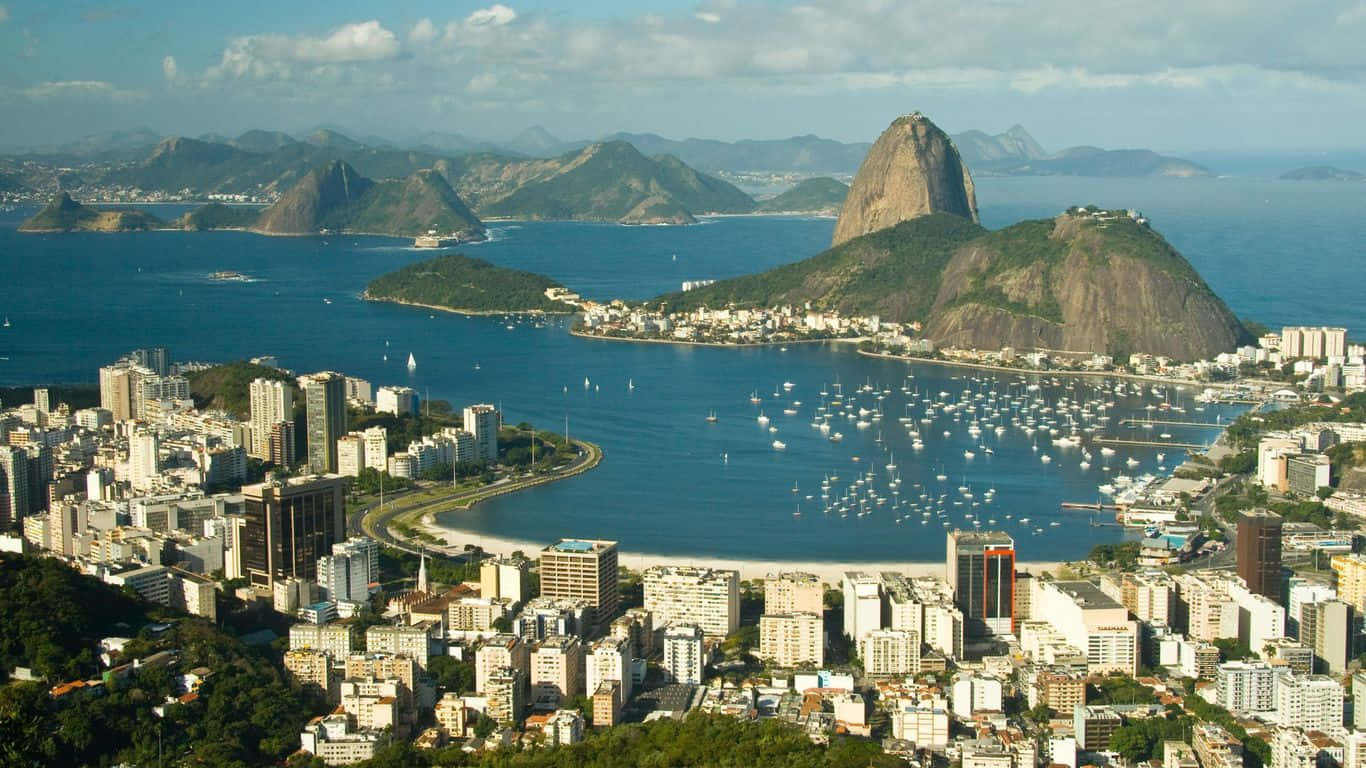 Brazil 桌布 壁紙 — 里約熱內盧的鳥瞰圖，展示了甜麵包山和充滿帆船的瓜納巴拉灣，天空部分多雲。