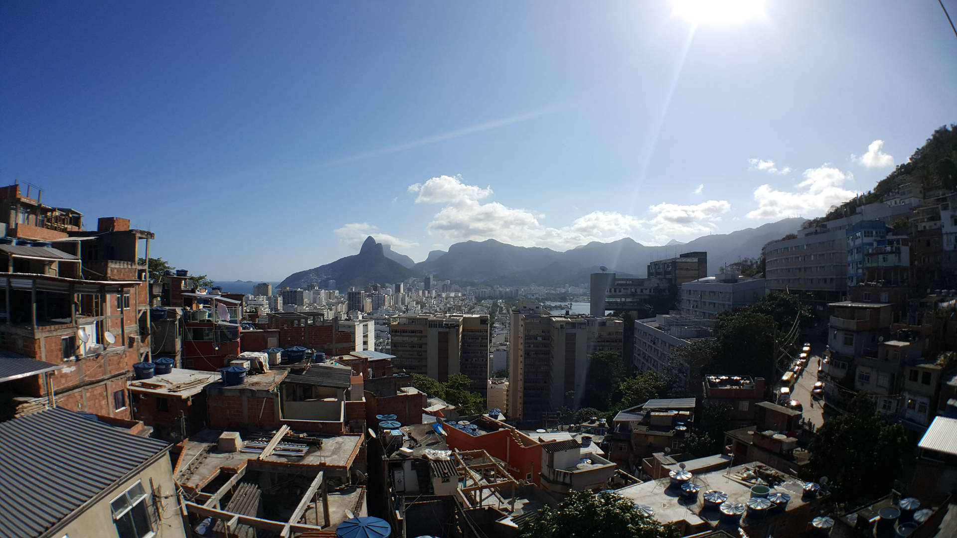 陽光普照的城市景觀，山丘上的紅磚建築俯瞰海灣和群山