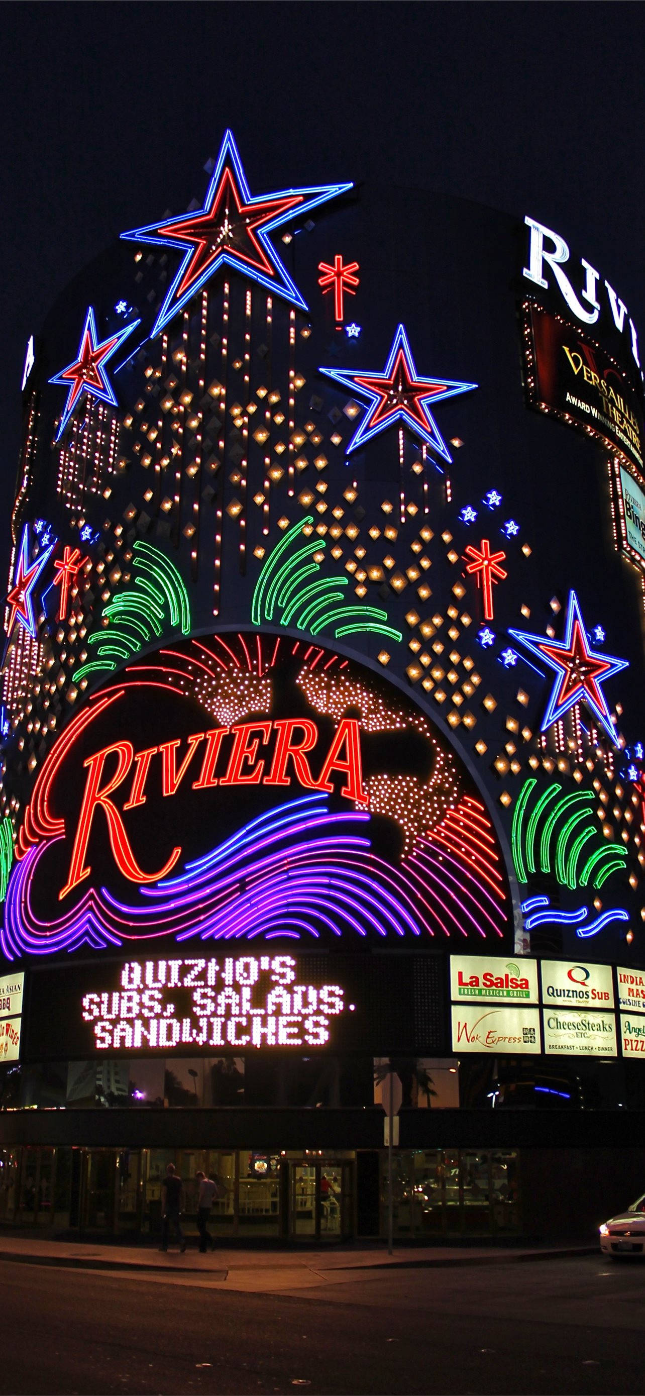Las Vegas Night 桌布 壁紙 — 里維埃拉酒店標誌性霓虹燈招牌在黑暗天空下閃爍星星和彩色燈光的迷人夜景。