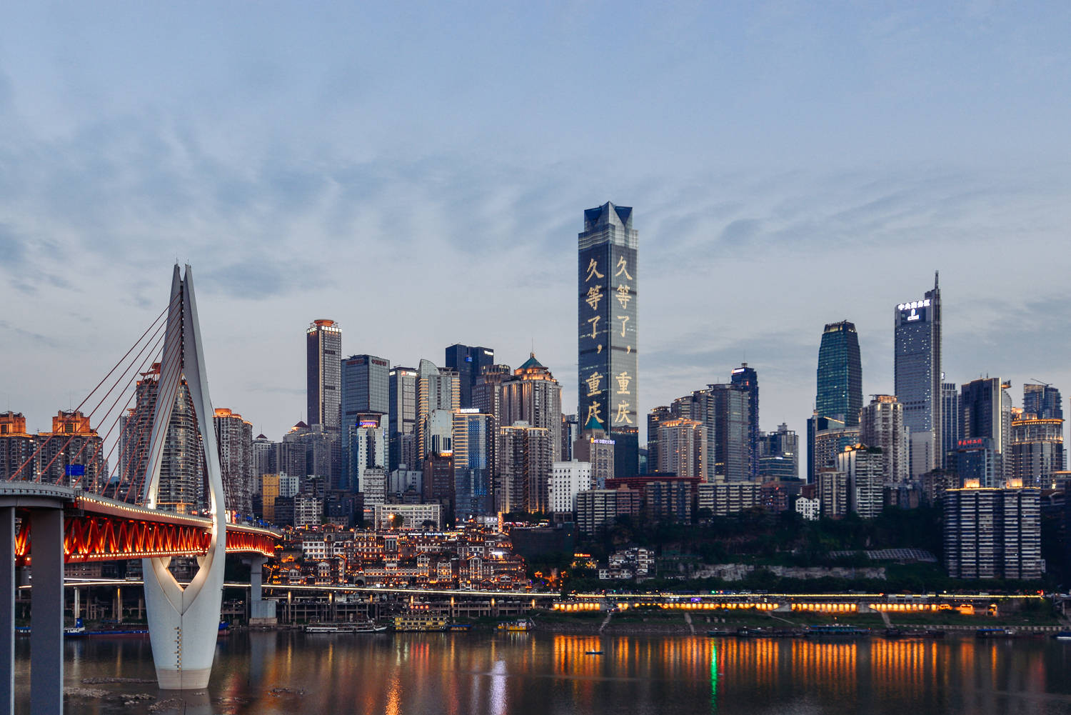重慶中國都市風景 壁紙 — 重慶天際線的壯麗黃昏景色，發光的橋樑橫跨反射的河流，摩天大樓燈火輝煌。