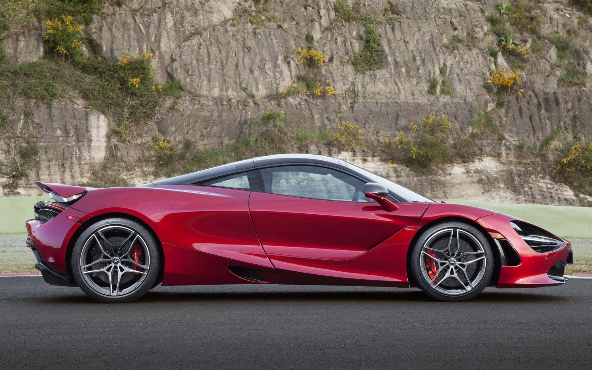 紅色McLaren 720S跑車在賽道上，靠近岩石懸崖。
