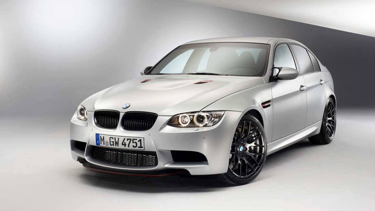 銀色BMW M3運動轎車，配備黑色輪圈和紅色飾條，在攝影棚燈光下。