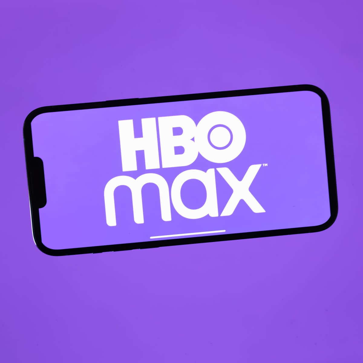 在紫色背景的智能手機屏幕上顯示的HBO Max應用程式標誌。
