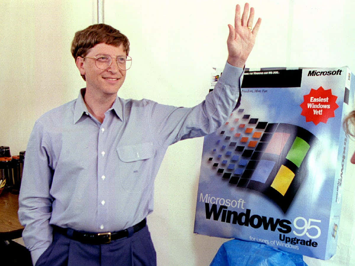 「重返未來：Windows 95」 壁紙 — 比爾·蓋茲微笑並揮手，旁邊是帶有彩色像素標誌的 Microsoft Windows 95 升級盒。
