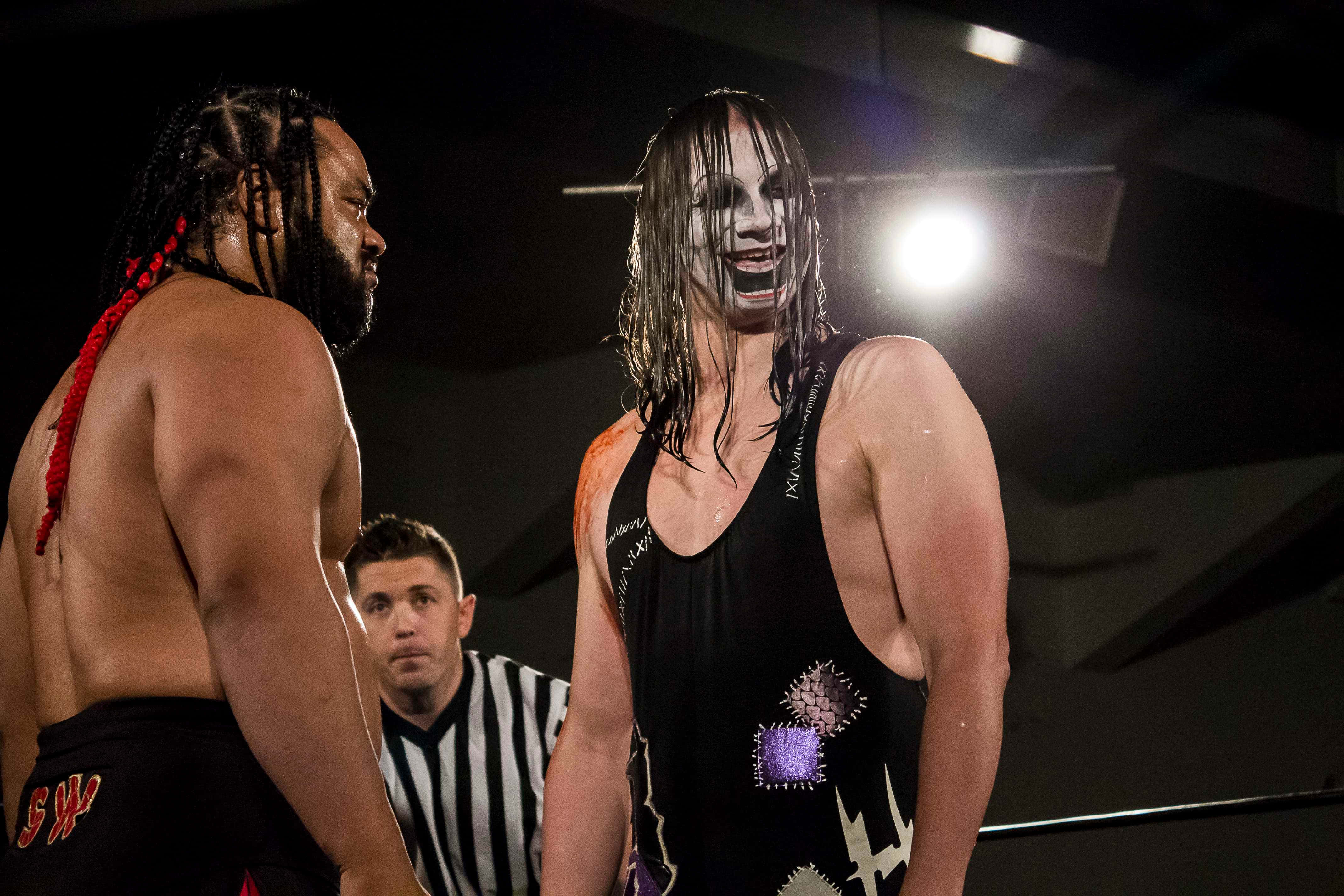 重量級摔角手雅各布·法圖 Major League Wrestling 壁紙 — 兩位激烈的摔角手在明亮的場館燈光下對峙，裁判在旁密切注視。